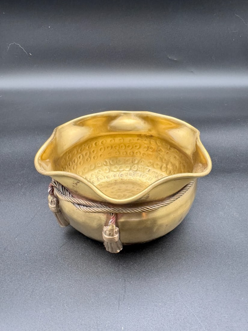 “Knot On The Neck” Hammered Brass Bowl: This item is a vintage solid hammered brass bowl or planter, featuring a scalloped rim and rope tassel detailing. These pieces were commonly handcrafted in India and are popular decorative