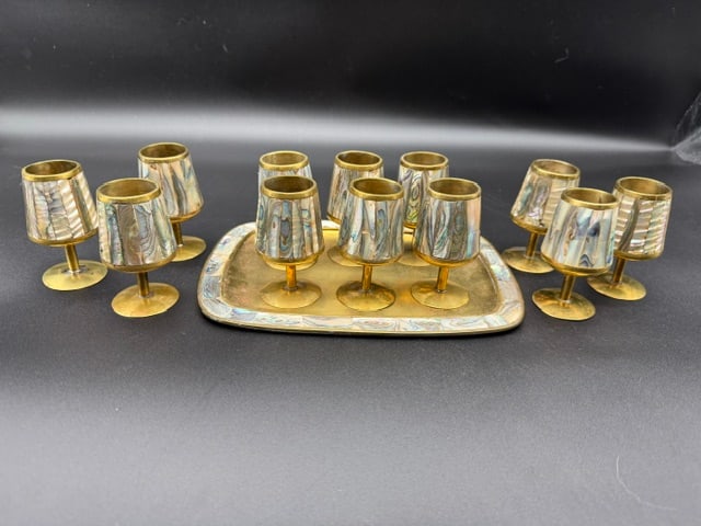 1950s Mexican Barware Made Of Brass with Abalone Shell Tiles Inlay with 12 Glasses and Tray: This is a vintage 1950’s Mexican barware set consisting of 12 shot glasses and one serving tray made brass with abalone shell tile inlay. Abalone shell is a type of marine mollusk and is known for