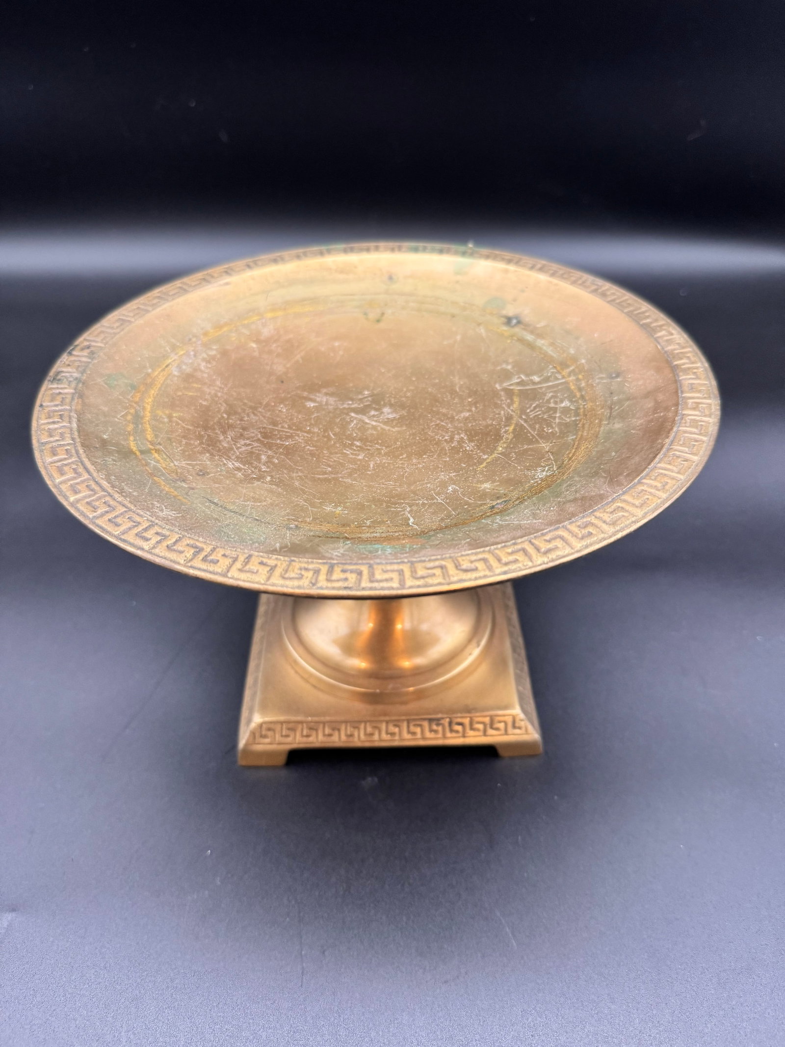 Neoclassical Solid Brass Pedestal: Neoclassical solid greek key brass pedestal. The foot plate on the bottom is missing where more than likely the makers mark would be stamped.