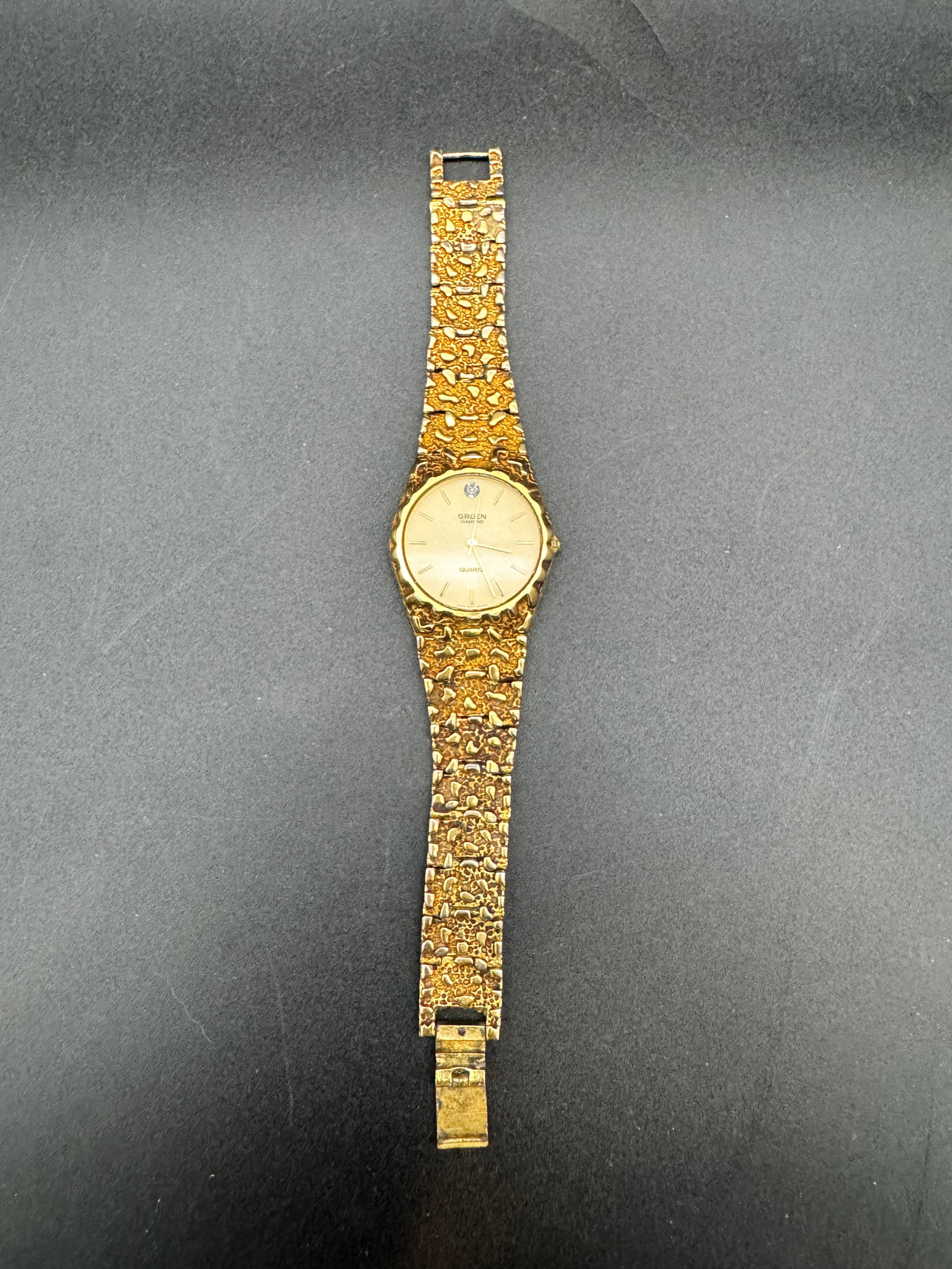 Vintage Gruen Diamond Gold Nugget Gold Plated Nugget Textured Men’s Watch w/ Box: This is a vintage Gruen Diamond Gold Nugget wristwatch along with its original box. Featuring a quartz movement and a gold plated nugget textured bracelet.