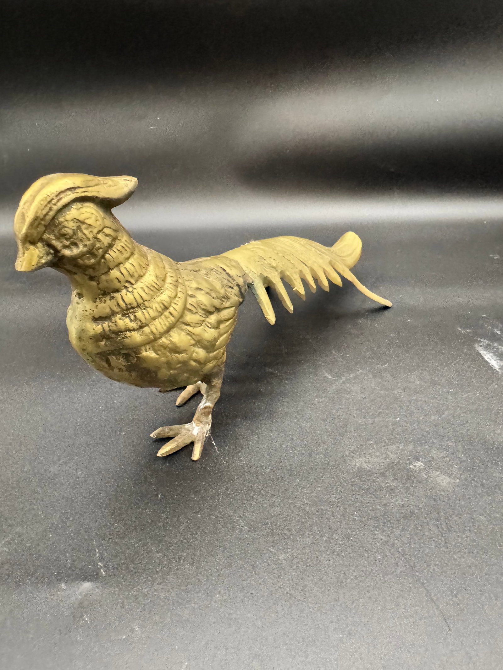 Vintage Brass Pheasant: Solid brass featuring a natural patina developed over time, vintage brass pheasant figurine. Era is mid-20th century, with intricate etched detailing on the feathers and a long tail. This not only