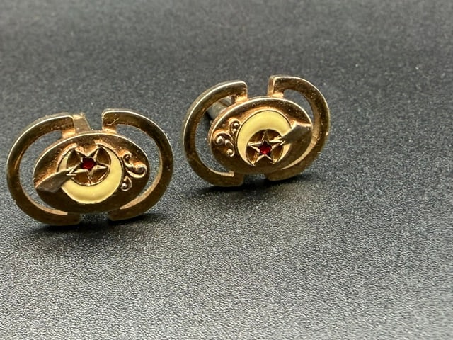 Masonic Shriner Cuff Links: Masonic Shriner Cuff Links are collectible pair of Masonic Shriner items, featuring a crescent moon, a red-enameled star, and a scimitar design. Oval gold-toned cufflinks with prominent crescent moon