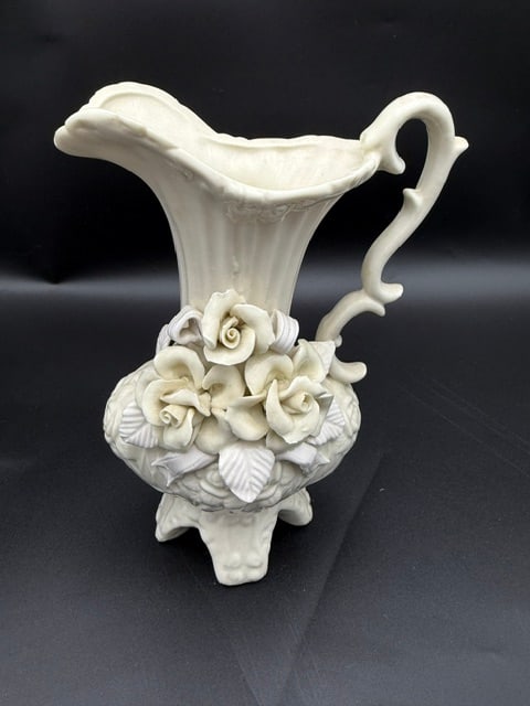 White Ceramic Footed Pitcher W/ Flower: A Belleek STYLE pottery piece (no stamp on the bottom, different footing) Featuring applied floral relief decoration. All white, matte piece.