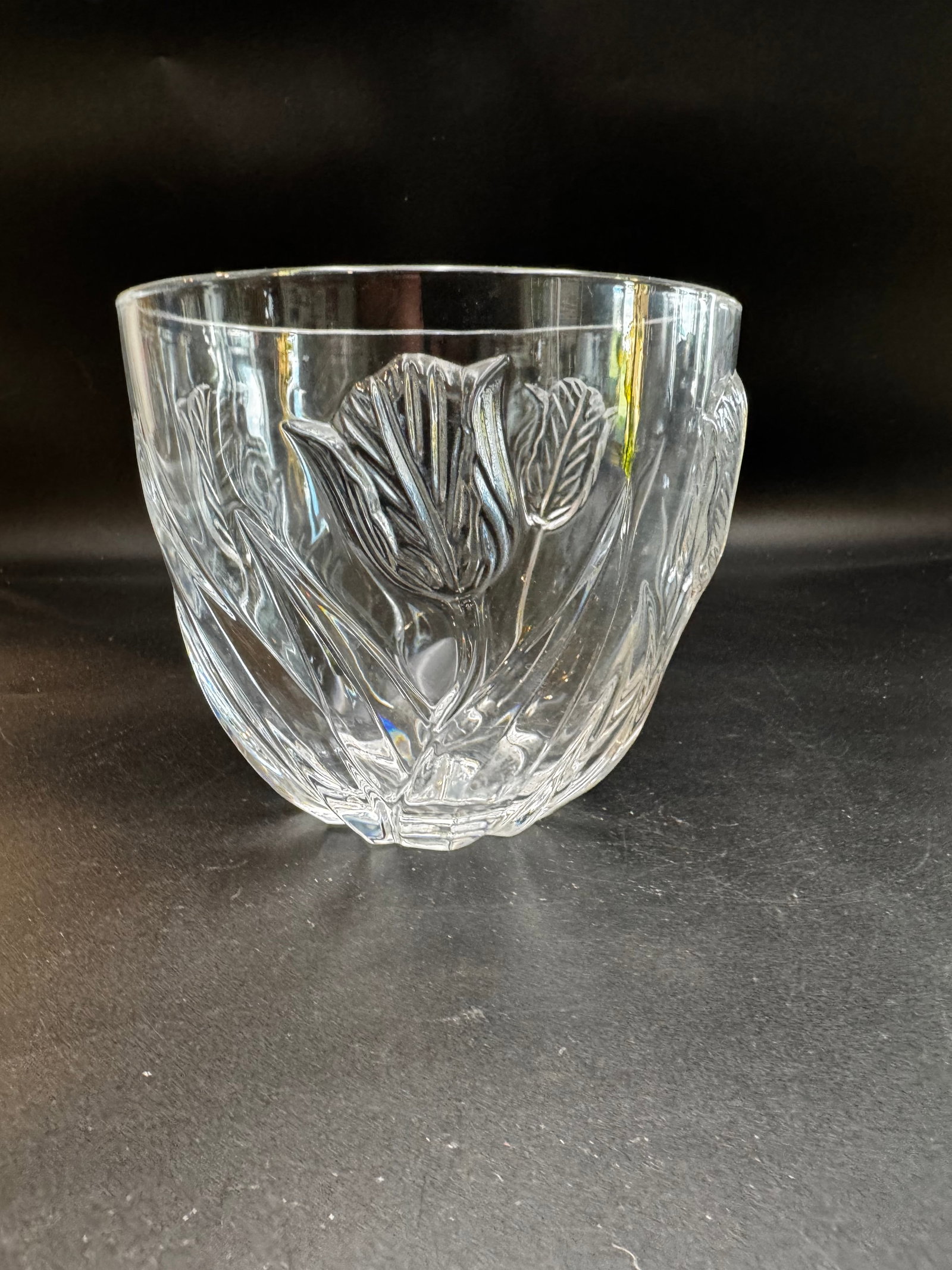Vintage Cristal De France Lead Crystal Tulip Bowl: The item in the selected region is a vintage Cristal De France 24% lead crystal tulip bowl. It features an embossed, raised tulip and leaf motif wrapping around the exterior while remaining smooth on 