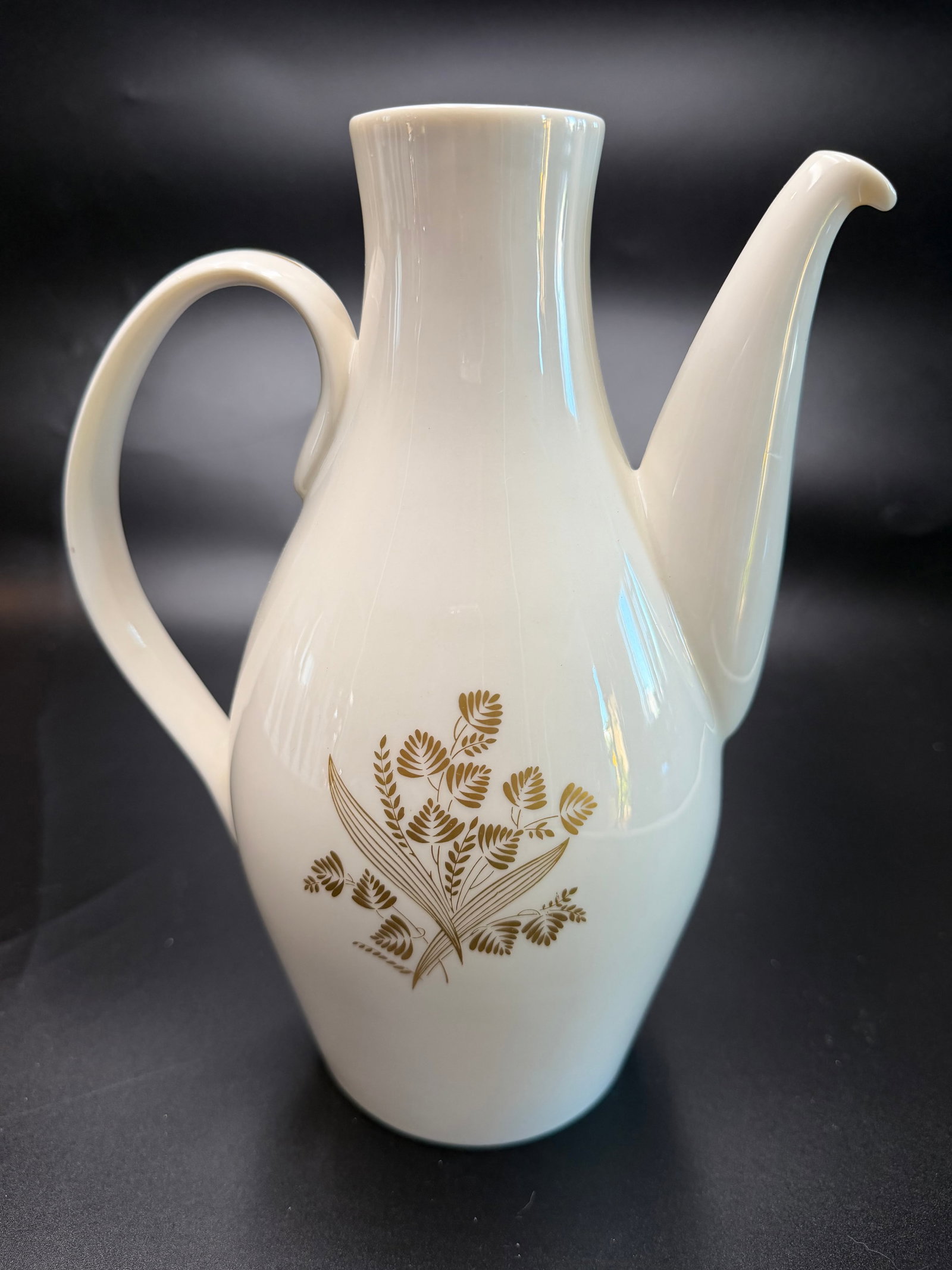 Vintage Castleton China Coffee Pot in Golden Meadow Pattern: The mid-century modern "Museum White" ceramic body shape was originally created for Castleton by the iconic industrial designer Eva Zeisel. The gold floral and leaf center graphic was designed by Phil