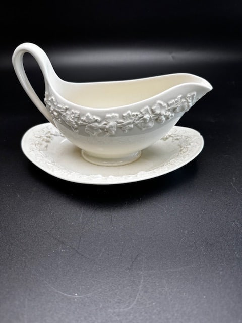 Vintage Wedgwood Embossed Queensware Gravy Boat: This vintage Wedgwood Queensware gravy boat and attached underplate in the "Cream on Cream" colorway featuring an embossed grapevine pattern. The raised decoration is the classic Embossed Queensware