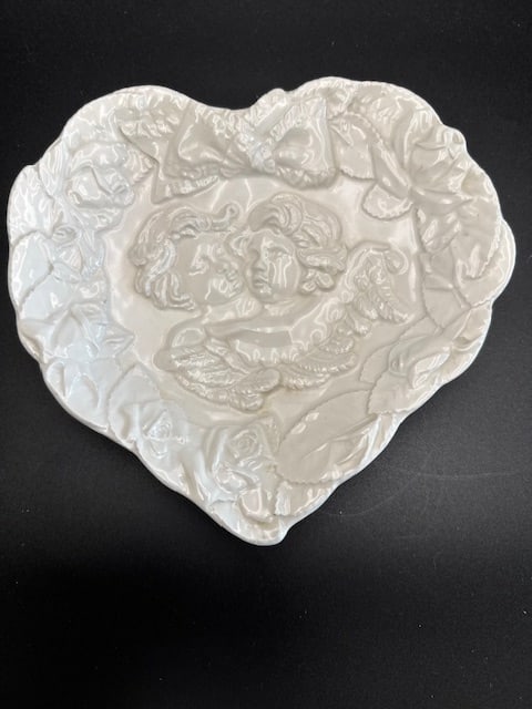 Ceramic Heart Shaped Dish Featuring Embossed Cherubs and Roses: This white ceramic heart-shaped dish featuring embossed cherubs and roses, Made in Italy. Marked 7360 Made in Italy on the bottom. Likely produced between 1960 and 1980. Romantic decor trend features