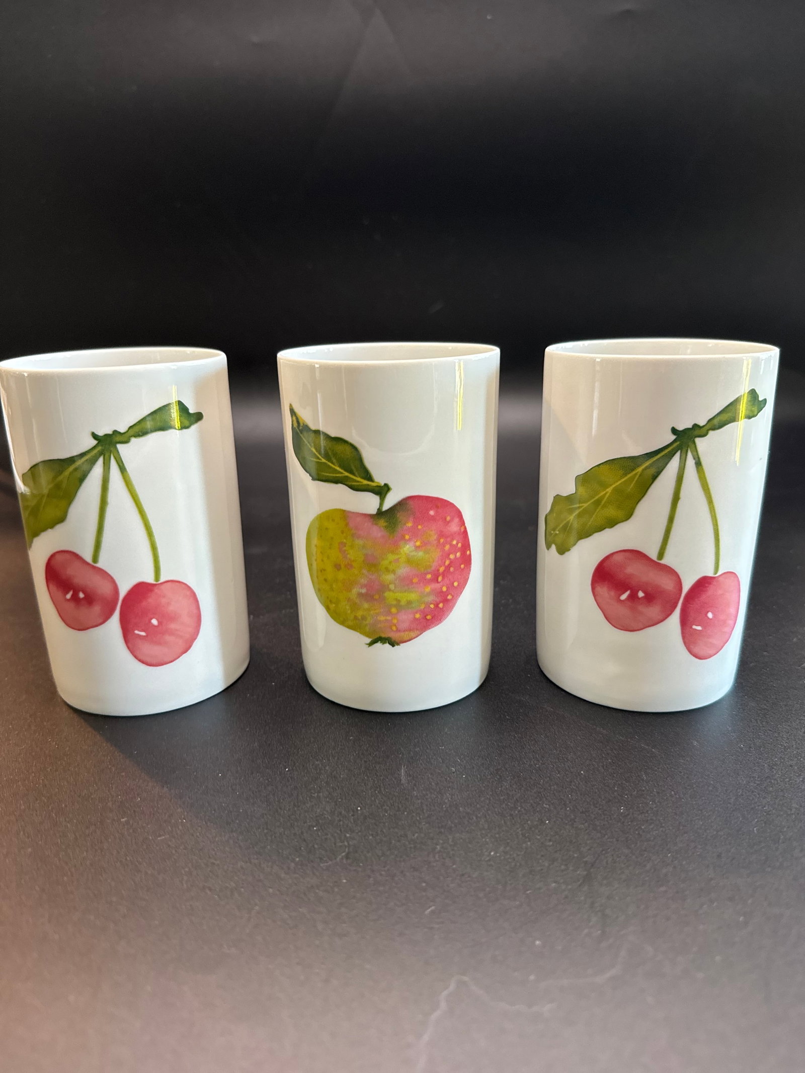 Johann Haviland Tumbler Set (set of 3): This is a Johann Haviland tumbler featuring a watercolor apple and cherry design, consistent with vintage German ceramic tableware. Each glass is 4” H x 3” Diameter. Measurements and