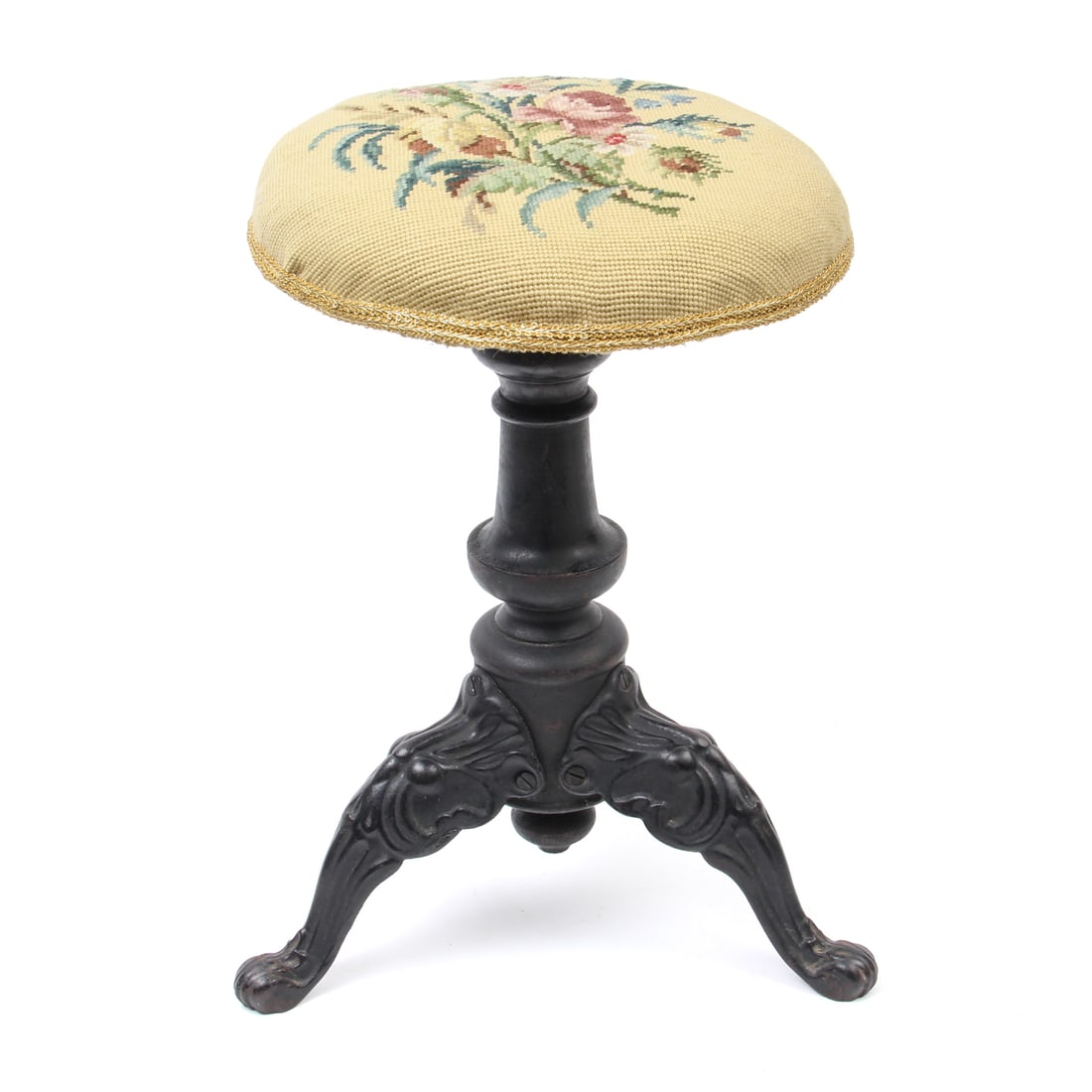 Floral Needlepoint Victorian Stool: An antique stiil with cast iron legs, turned wood center column, and floral motif needlepoint cushioned top. 13w, 18h inches.