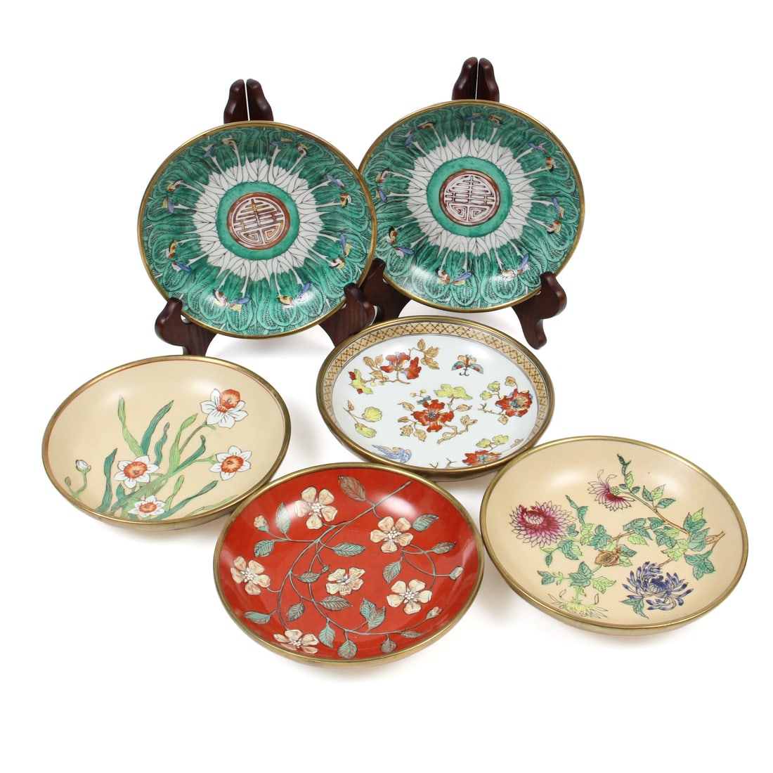 Bombay Bok Choy Brass Wrapped Plates and More: This lot features a pair of bok choy designed plates wrapped in brass by the Bombay Company, also included are four hand decorated asian style plates also wrapped in brass to the underside and rim.