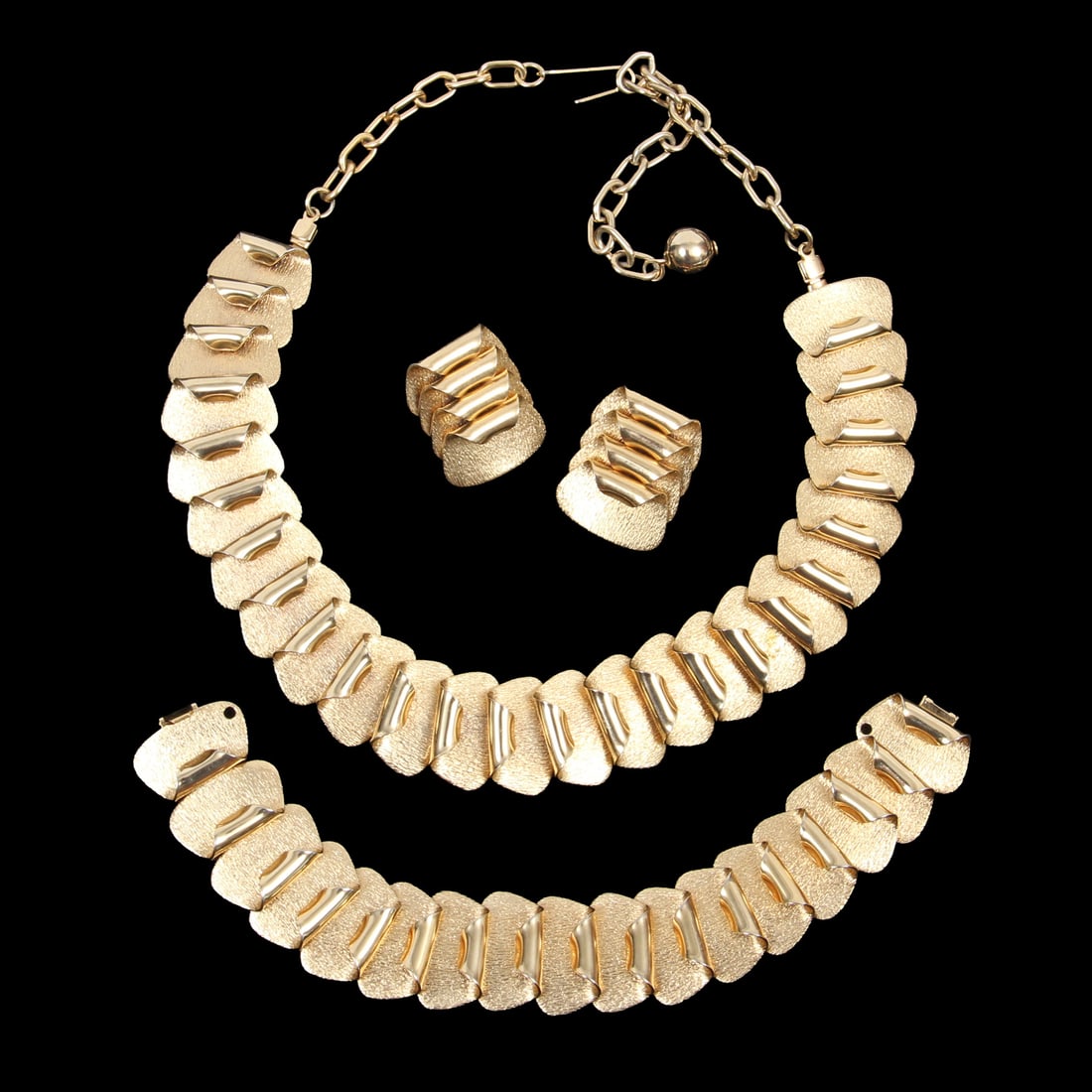 Vintage Brass Demi-Parure: A vintage solid brass demi-parure including a necklace, bracelet, and pair of clip-on earrings. Bracelet is 7 inches long flat, necklace measures 18 inches long flat including chain.