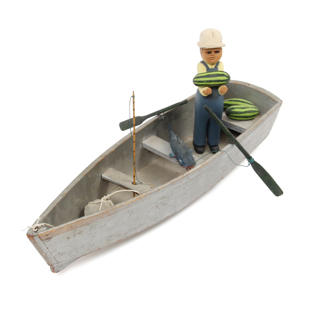J. Cook Folk Art Fishing Man Sculpture, 1983: A vintage folk art sclpture by artist J.Cook. This piece includes a carved man with his arms extended, 3 watermelons, 2 oars, 1 fishing pole, and 1 rock anchor. These pieces have a hand-painted