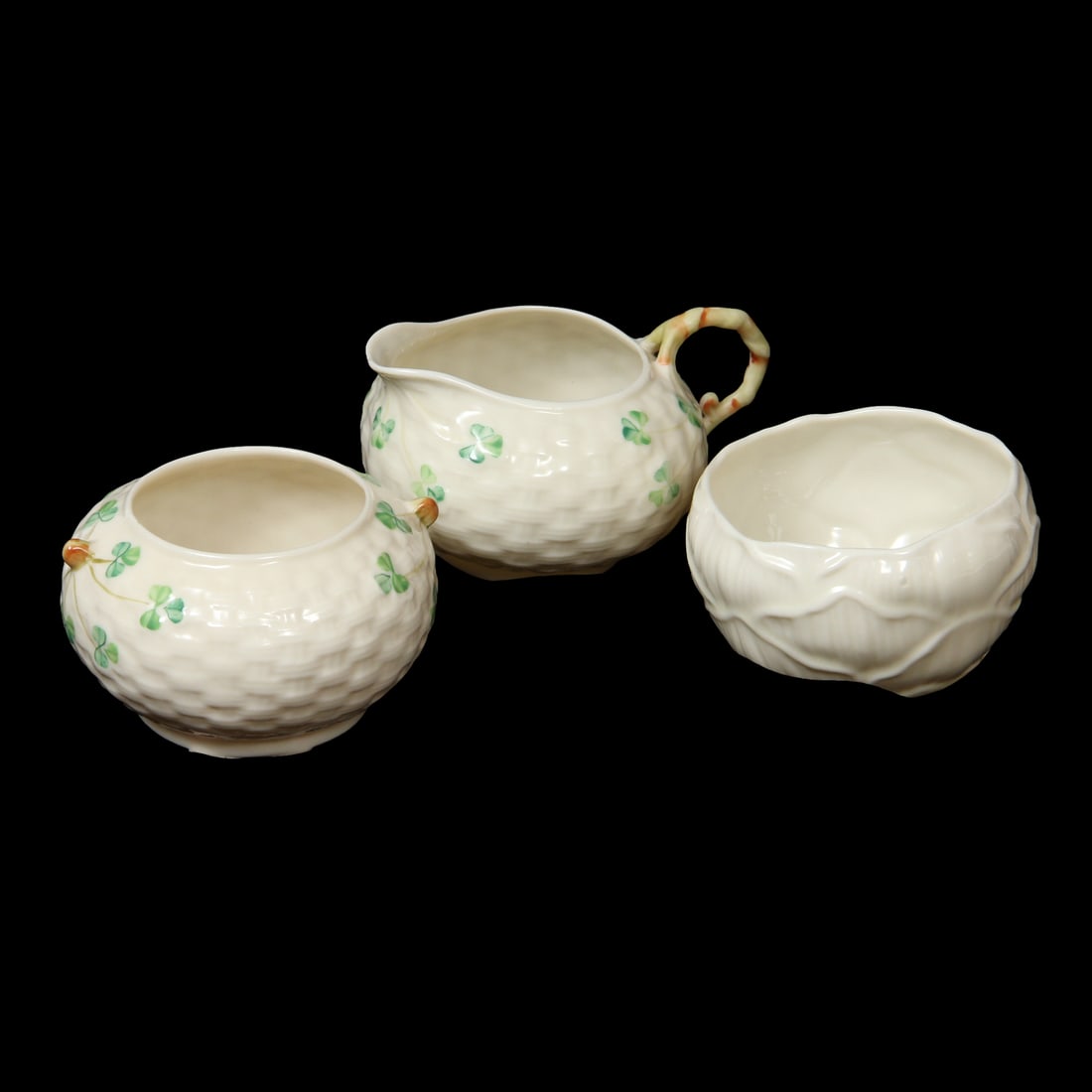 Belleek Ireland Porcelain Pieces: A collection of Belleek porcelain china pieces including a creamer and sugar with clover designs, and another single sugar bowl. 4.75w, 3h inches (of creamer)