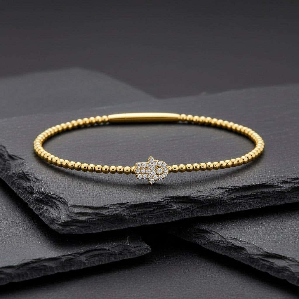 Diamond Hamsa Charm 14K (or 18k upon request) Gold Beaded Bracelet: This delicate bracelet adds a touch of sparkle to any outfit. Available in White, Yellow, or Rose Gold, it’s the perfect piece for every occasion. Designed to fit comfortably with a one-size-fits-al