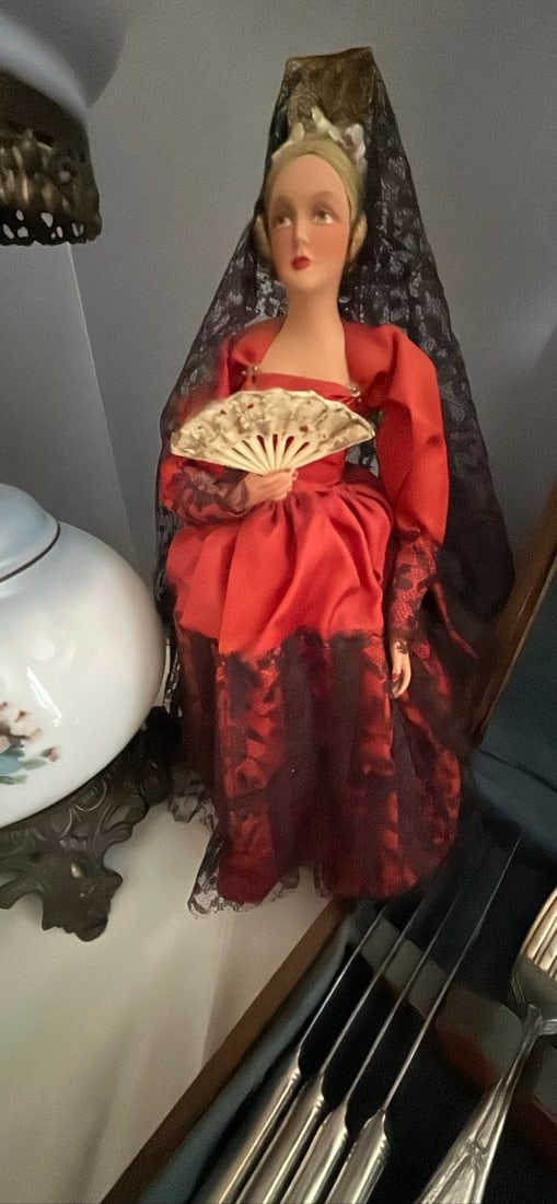 Vintage Spanish Flamenco Doll with Fan: This charming vintage doll is dressed in a vibrant red flamenco outfit and holds a decorative fan. A perfect addition for collectors or as a decorative piece. (Good)