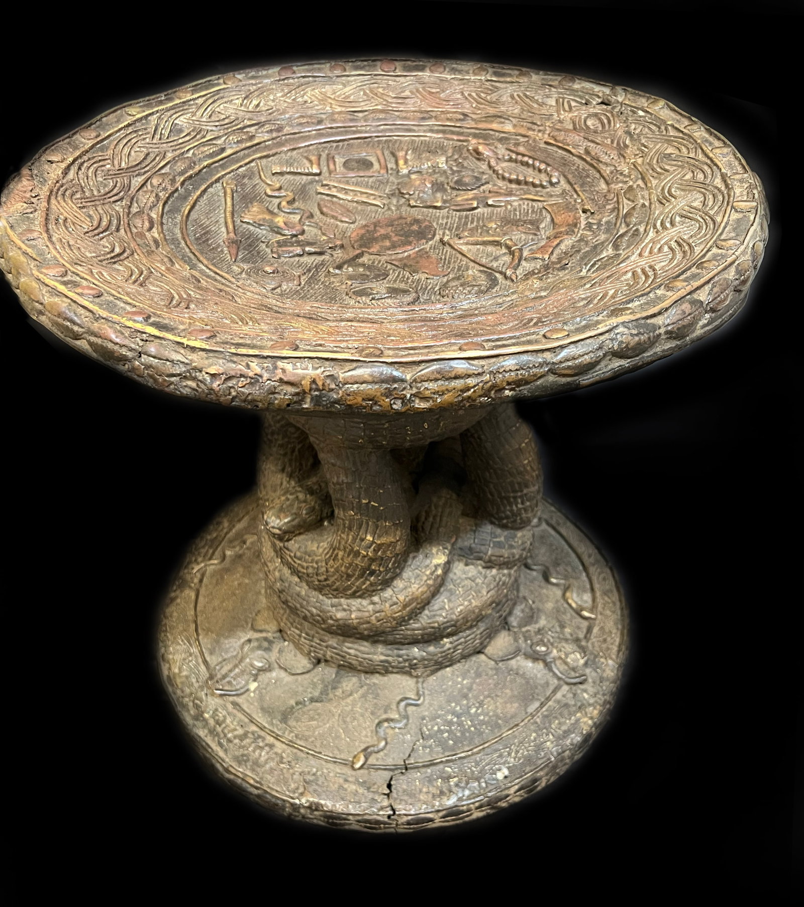Antique Benin Style Bronze Pedestal Table with Coiled Serpent Base: This 16-inch bronze pedestal table is a masterpiece of lost-wax casting, showcasing the intricate iconography found in historical West African court art. The piece serves as both a functional surface 