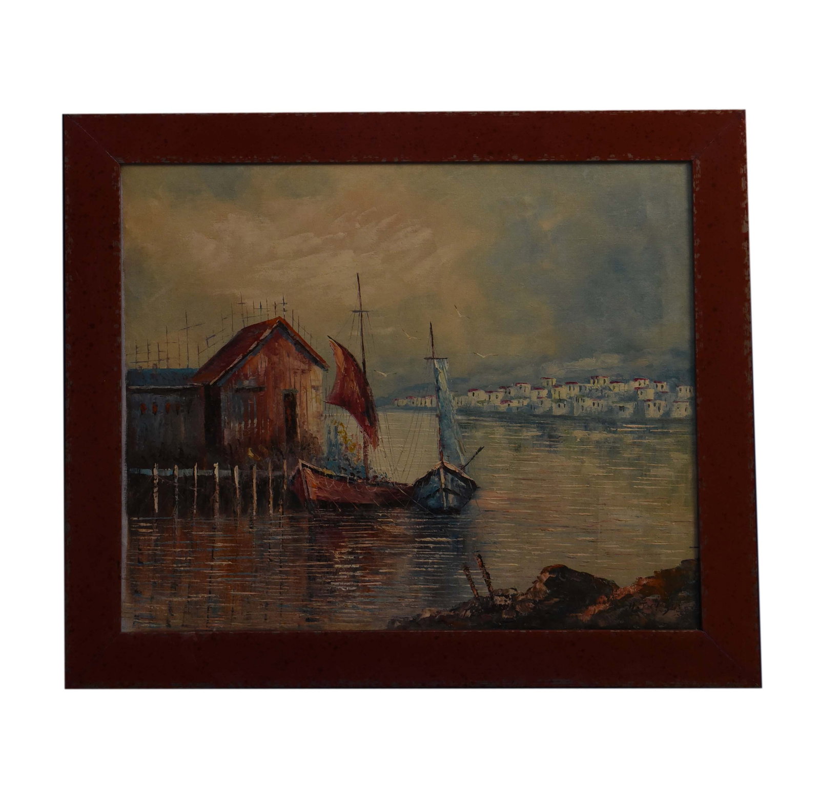 Harbor Serenity Oil On Canvas: An enchanting oil on canvas painting, measuring 28" x 25", captures a serene harbor scene. A rustic red boathouse stands prominently by the water, flanked by two sailboats gently bobbing in the calm r