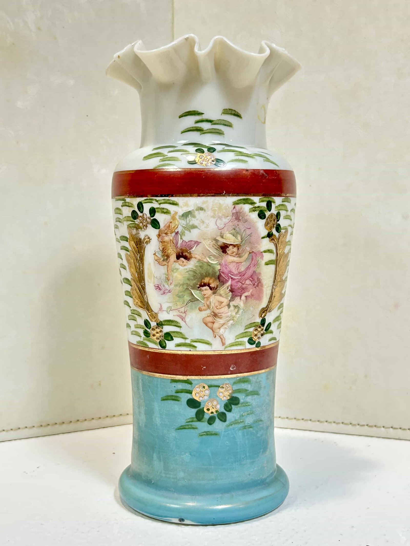 Hand Blown Opaline Glass Vase w/ Ruffled Rim, Hand Painted Cherub Floral Motif: Beautiful antique hand blown opaline opaque glass vase w/ ruffled rim. There is a cherub and floral motif hand painted on one side, with blue and red bands going all the way around. The vase measures 