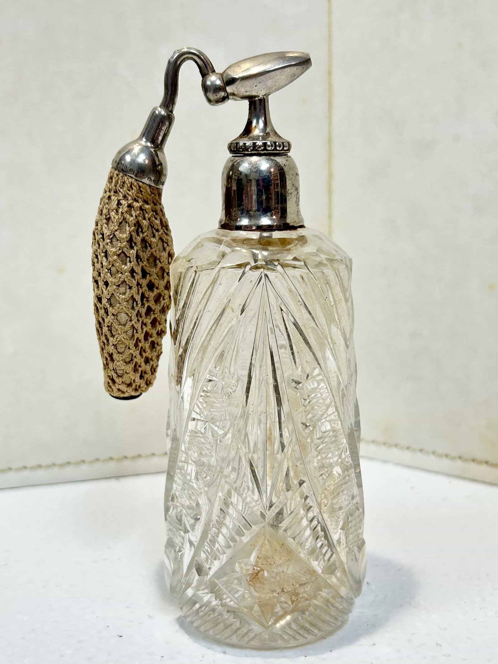 Antique Cut Crystal Perfume w/ Devilbiss 1908 Atomizer: Antqiue cut crystal, measures 6" tall. Rubber on the atomizer is hardened, not usable. Top is silver plate. Crystal is in good condition with no visible chips or cracks.