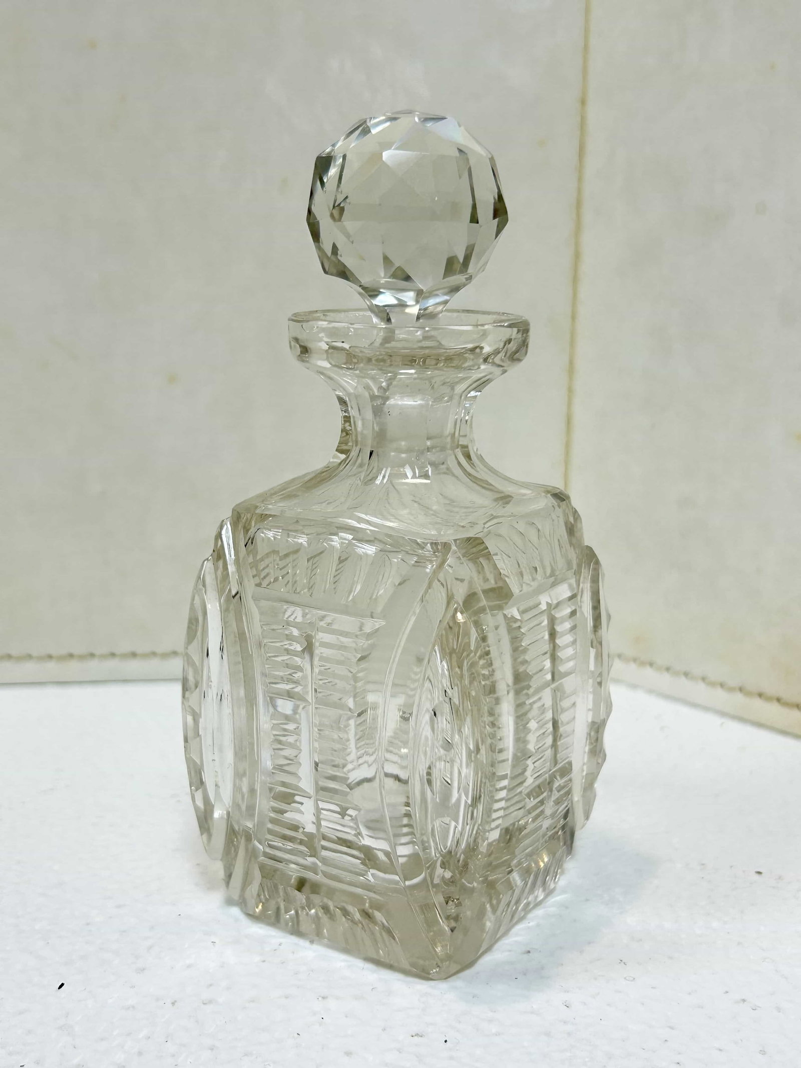 Antique Cut Crystal Perfume Bottle w/ Glass Stopper: Beautiful cut crystal perfume bottle, unmarked. Has square body w/ round stopper, measures 5.5" tall. Lip of bottle is a little rough, and has a small chip in the stopper?no cracks in crystal.