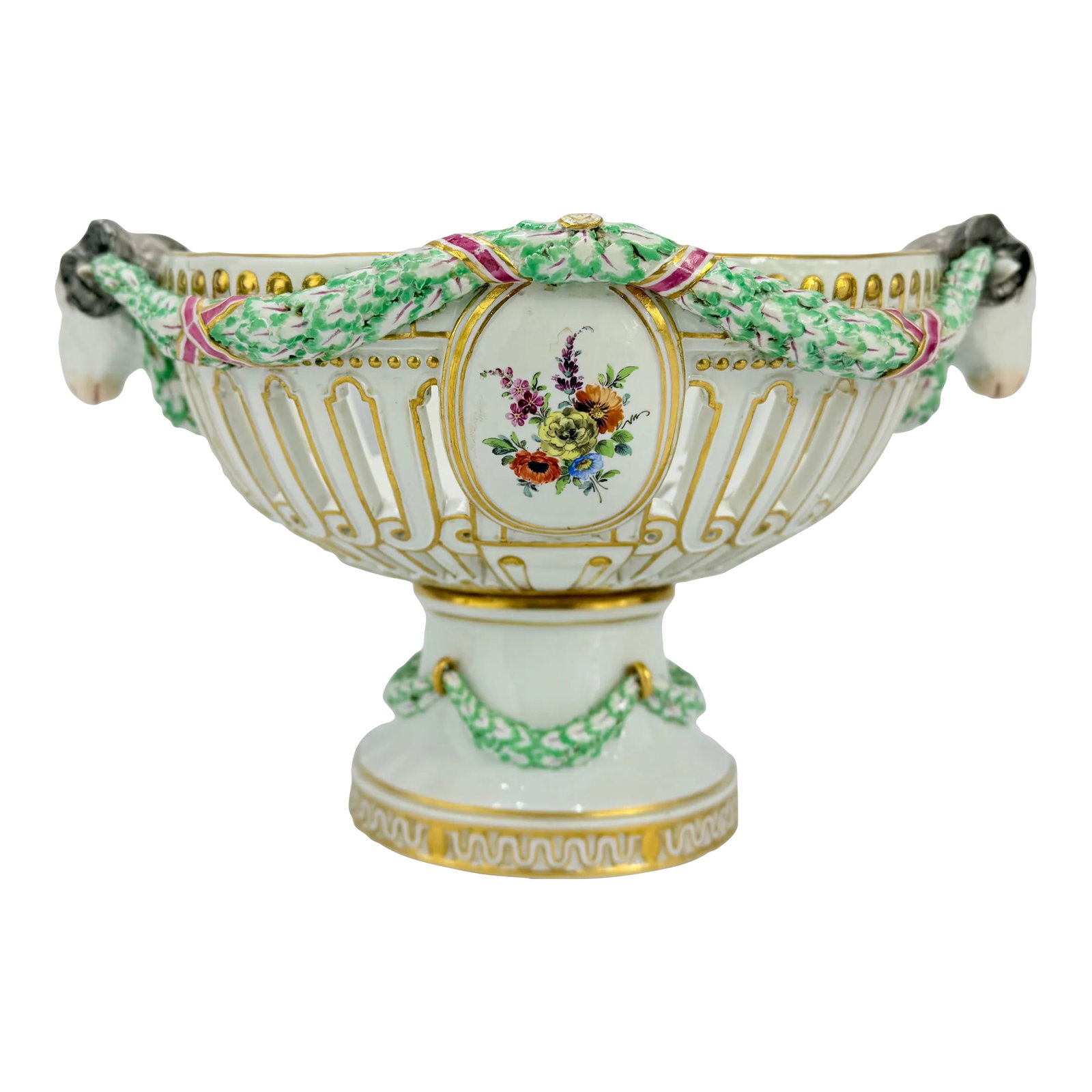 19th Century, Meissen Porcelain Ram's Head & Floral Centerpiece: A Meissen porcelain centerpiece of oval openwork construction, two floral windows oppose each of the main bodies of the piece and are flanked by a pair of beautiful ram's head handles connected with