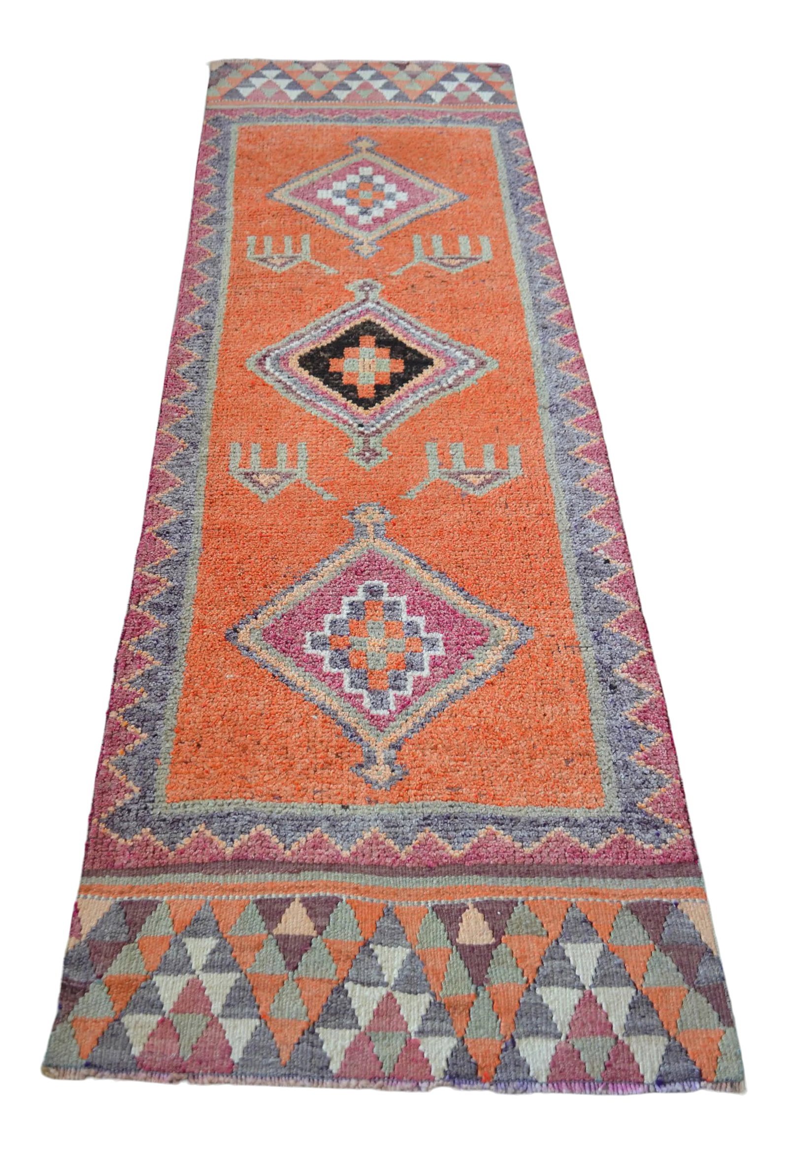 1960s Vintage Hand Knotted Primitive Turkish Runner: Woven by skilled artisans in Southeastern Anatolia during the 1970s, this vintage hand-knotted runner rug is a striking example of authentic tribal craftsmanship. Its dynamic geometric motifs and