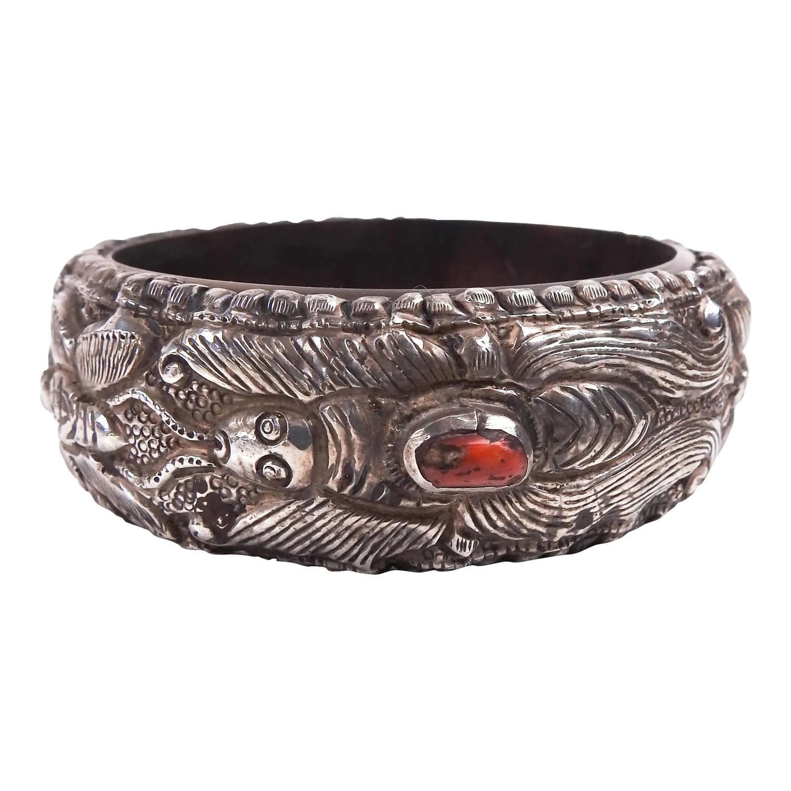 Vintage Tribal Repousse Silver and Coral Bracelet: Vintage sterling silver repousse work bangle with three bezel set red coral pieces. Silver is an old piece which has been firmly formed over newer dense plastic base. Repousse design has insects,