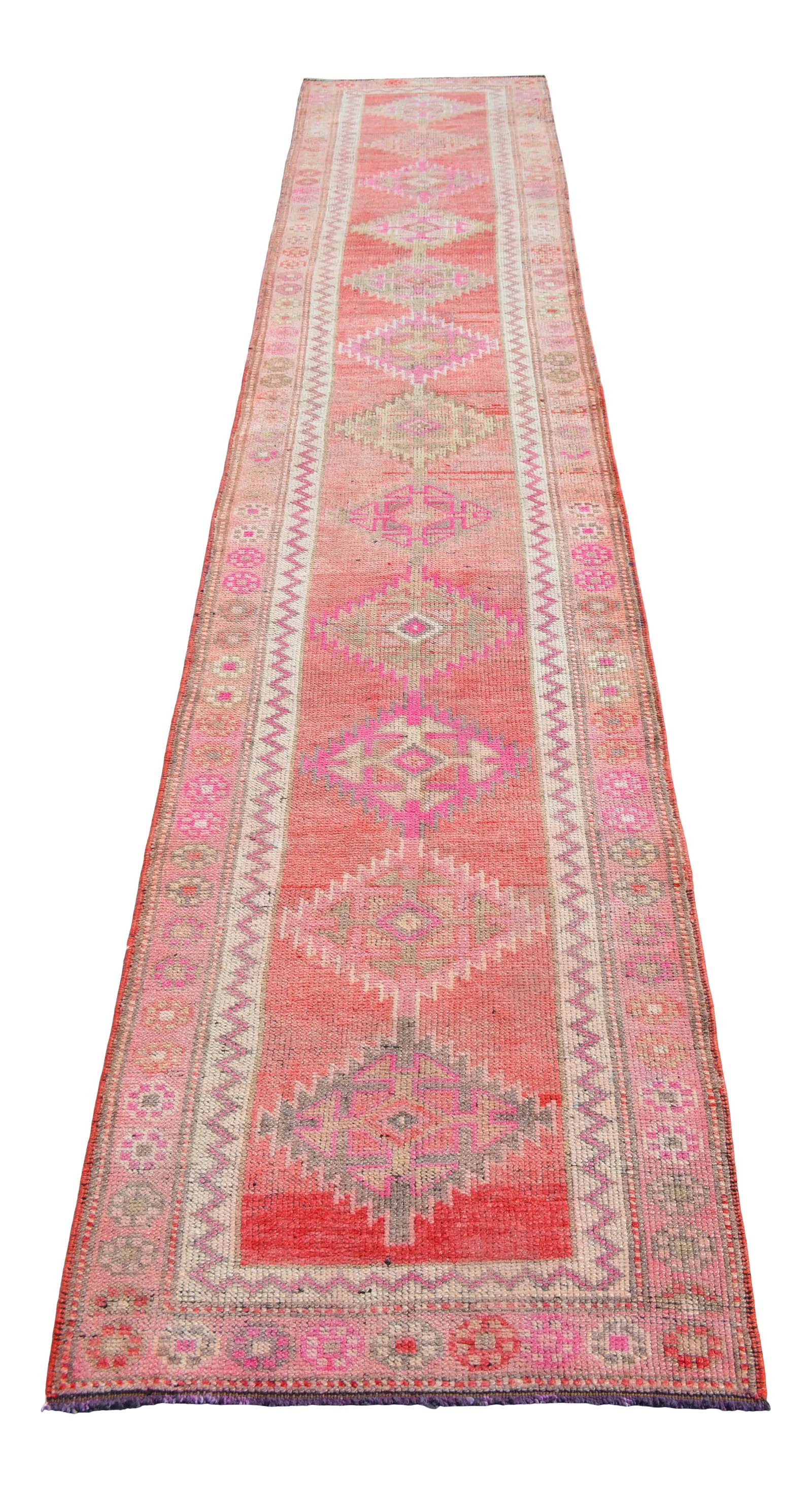 1970s Pink Kurdish Herki Hand-Knotted Distressed Runner: An exceptional example of mid-20th-century textile art, this vintage Turkish runner rug was hand-knotted by village weavers in Southeastern Anatolia during the 1970s. Originally created for personal