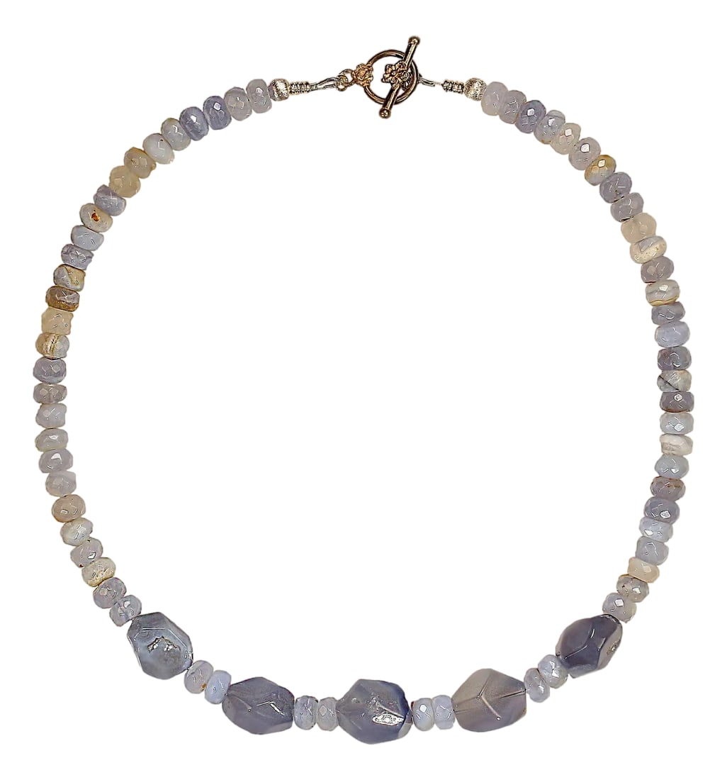 Ajd 17 Inch Blue Lace Agate Necklace: This elegant 17"‘inch blue lace agate necklace brings a soft, serene beauty to any jewelry collection. The piece features a strand of delicate, pale blue beads accented by five larger faceted