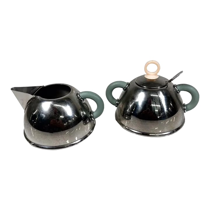 1985 Iconic Alessi Sugar Bowl + Creamer Designed by Michael Graves: AMBIANIC presents 1985 Iconic Alessi sugar bowl and creamer designed by Michael Graves. Made Taiwan Stainless Steel Creamer 5 x 4 w x 2.5 h Sugar 5 x 4 x 3.63 h Original sugar spoon included. Preowned