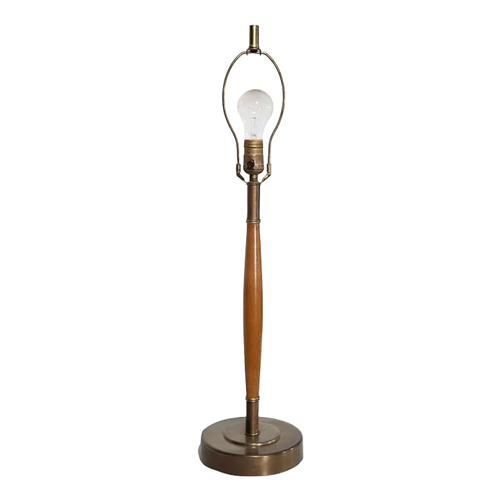Mid Century Table Lamp Att. To Thurston: Classic Mid Century table lamp design attributed to Gerald Thurston for Lightolier, unsigned. The lamp features an elongated wood center vertical pole, with brass fitments, on a circular metal plinth