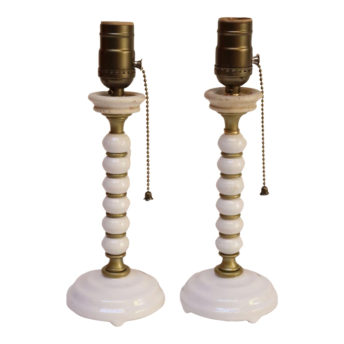 Pair of Vintage Stacked Bobbin Form Porcelain and Brass Boudoir / Bedside Lamps: Petite table lamps composed of stacked 'bobbin-form' ceramic rounds interspersed with brass accents and topped with wooden collars, all supported by round porcelain bases (ca. 1940s, USA). Elegant