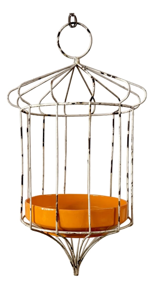 Mid-Century Modern White Wire Hanging Birdcage Plant Stand With Orange Ceramic Planter: This charming mid-century modern, 1950s hanging plant stand features a sculptural white-painted metal wire frame with a cage-like form and elegant tapered base. The airy wire structure creates a light