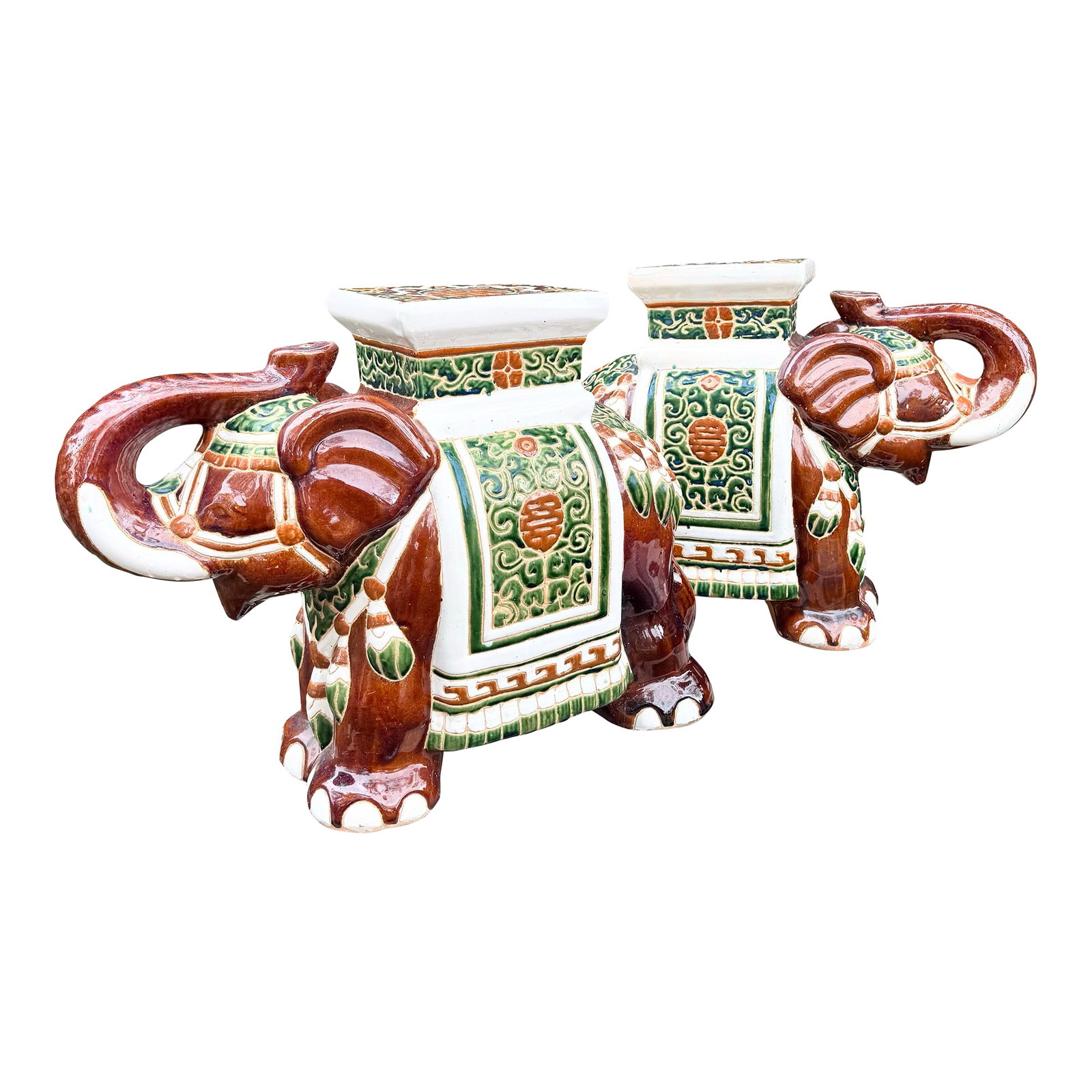 Boho Chic Painted and Glazed Ceramic Elephant Planters/Side Table - A Pair: Charming pair of Boho Chic ceramic elephant planters featuring richly glazed surfaces with decorative green and terracotta motifs. Each elephant is sculpted with raised trunk and ornate saddle