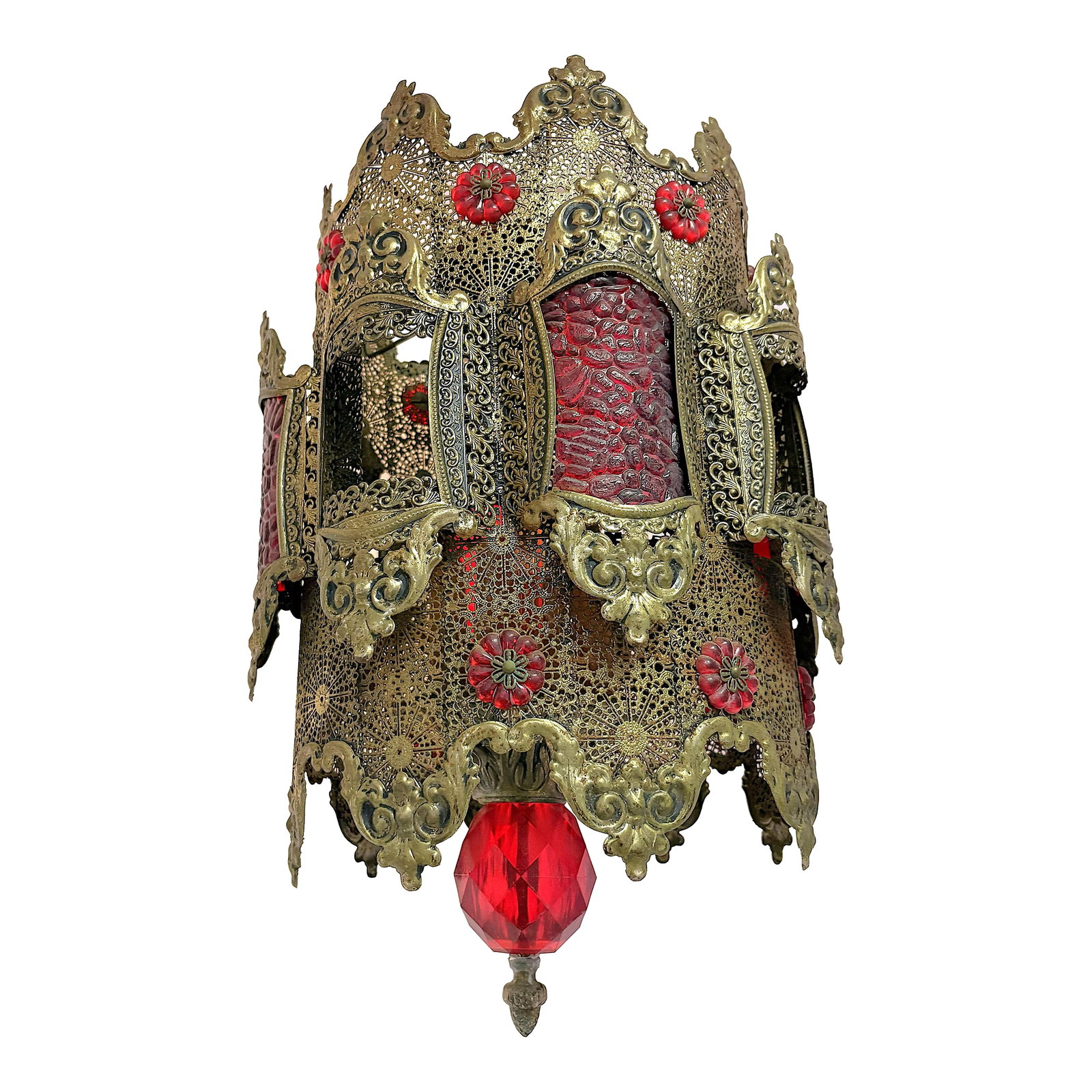 1970's Middle Eastern Hand Cut and Pierced Brass Pendant Lantern With Red Accents: Statement making brass filigree pendant lantern light fixture from the 1970's. The piece is made of hand cut and pierced brass with red glass and plastic accents. It has a cylindrical shape with