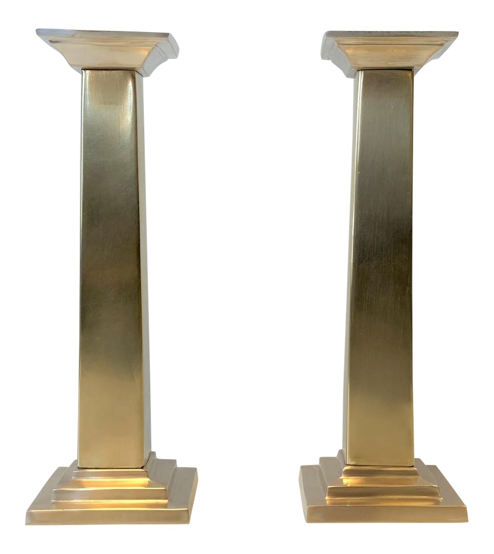 1980s Neoclassic Column Candlesticks - a Pair: This pair of neoclassic metal pillar candlesticks features a classic design. Silver toned cascading column caps compliment a contrasting gold toned post. Each candlestick measures 3" x 3" x 9"H with