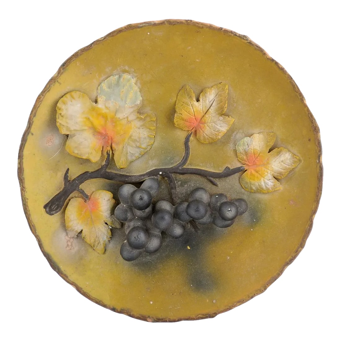 French 20th Century Wall Hanging Pottery Plate with Black Grapes Motifs: A French wall hanging pottery plate from the 20th century, with raised grape motifs. Created in France during the 20th century, this decorative plate features a mustard ground perfectly enhancing