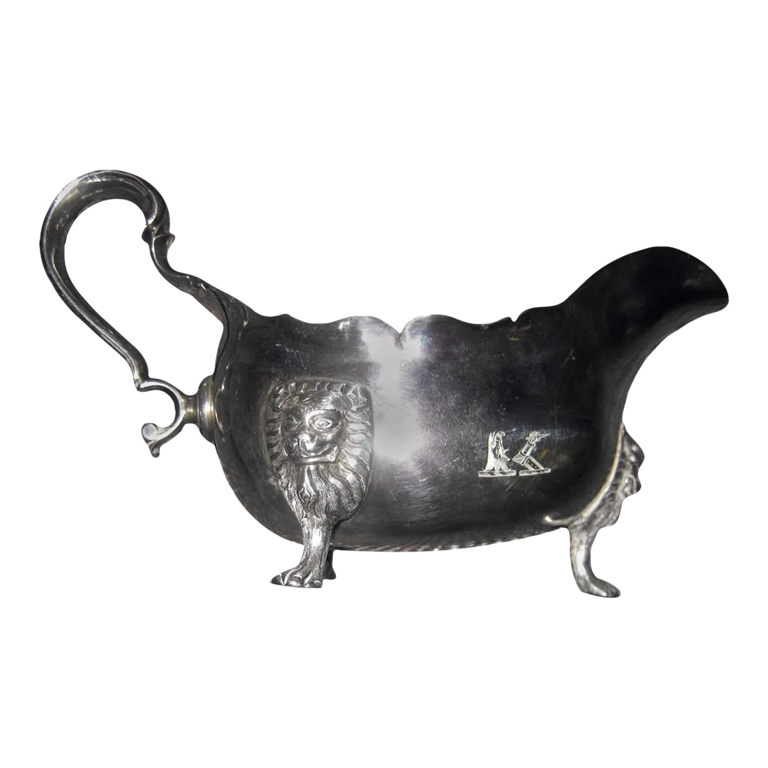 18th century Georgian Sterling Silver Irish Sauce Boat: Irish sterling silver sauce boat featuring lion heads tapering into paw feet, a scalloped edge, a graceful handle. Marked with the symbol of Ireland and the harp fineness symbol. The makers first