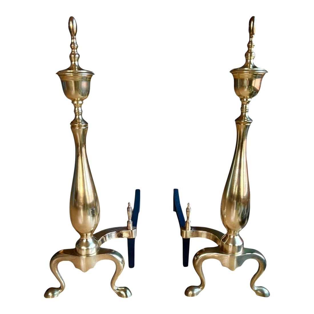 Restored Chippendale Style Vintage Brass Andirons- A Pair: Brass andirons or chenets with 22" tall vertical urn shape and topped finial. These chenets include a brass billet cap over curved iron bar with a second finial detail. The curvature and smooth lines 