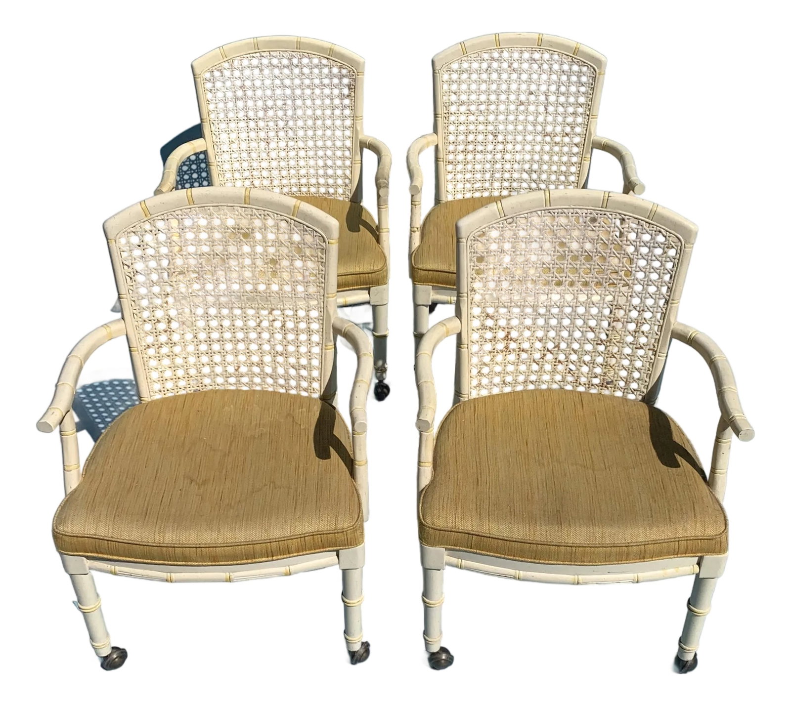 1960s Mid Century Yellow Cane Backed Chairs, Set of 4: Set of 4 painted mid-century wood cane backed chairs. Tight seat cushion upholstered in yellow woven linen fabric with antique brass caster wheels. Condition: Alterations: Original Condition