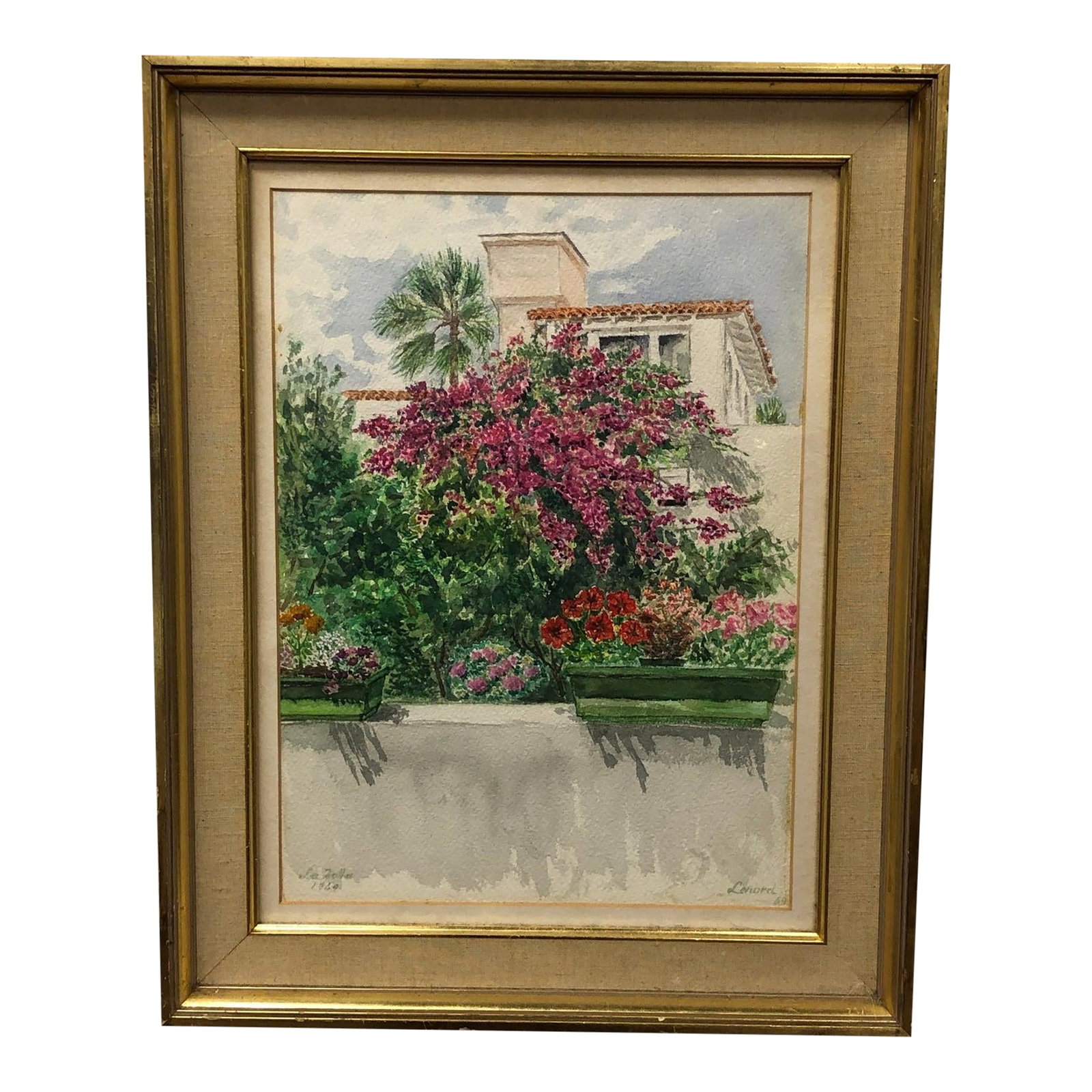 A Villa Hiding in Bloom - Original Watercolor Painting 1969 Signed on the Bottom, Framed: This original watercolor painting captures the inviting warmth and color of a sun-drenched Mediterranean garden, possibly set against the backdrop of a Spanish-style villa. A lush cascade of bougainvi