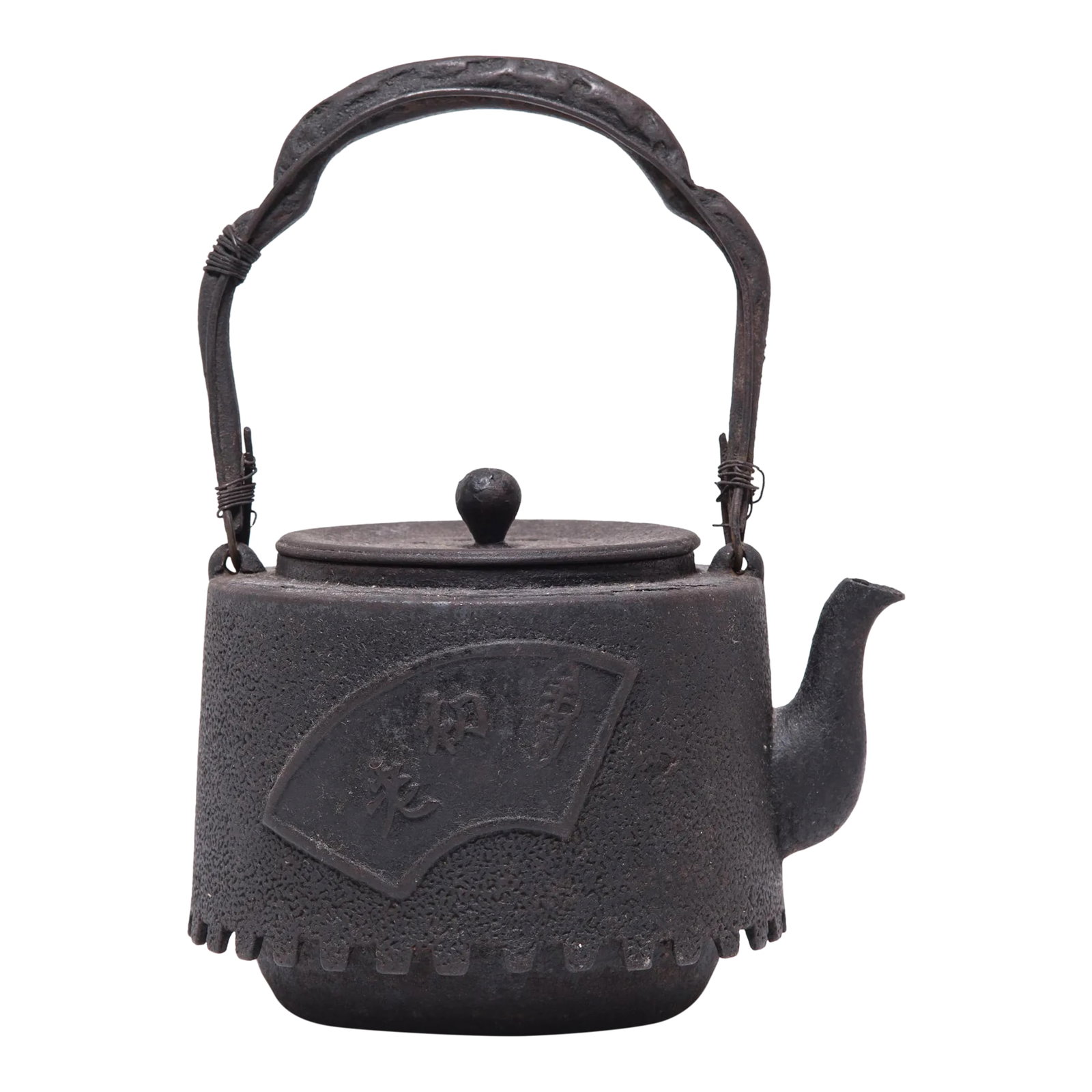 Fanning the Fire Antique Japanese Iron Teapot, C. 1920s: Decorated with a raised fan motif, this aptly named teapot was used to boil water for traditional tea ceremonies. The kettle's cast-iron construction is said to change the quality of the water, making
