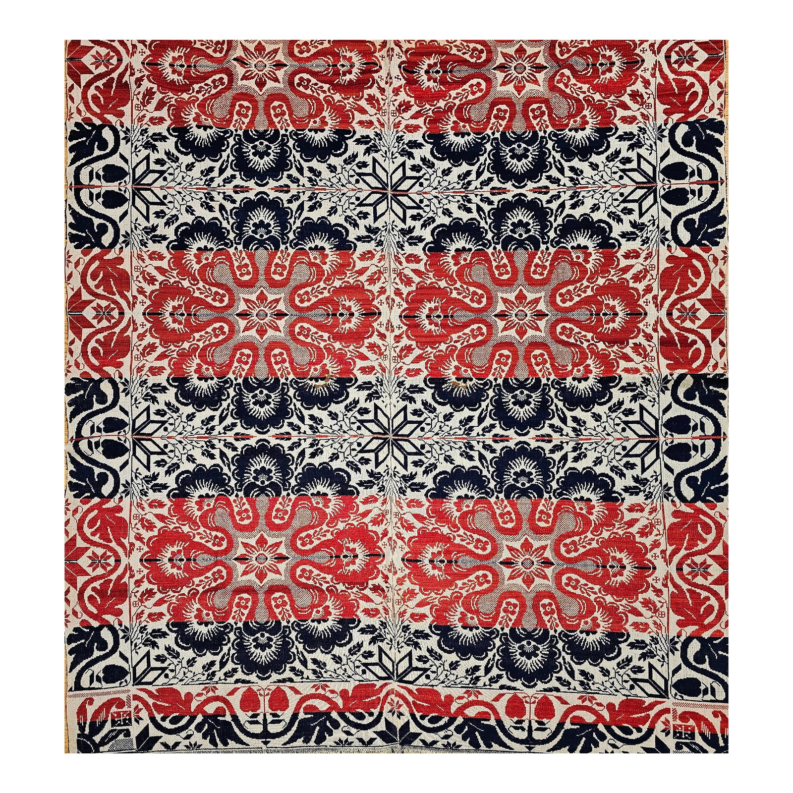 Mid 19th Century American Coverlet: This mid-19th century American tri-color coverlet is a striking example of early American textile craftsmanship, woven in red, blue, and white using a Jacquard loom. Featuring floral medallions