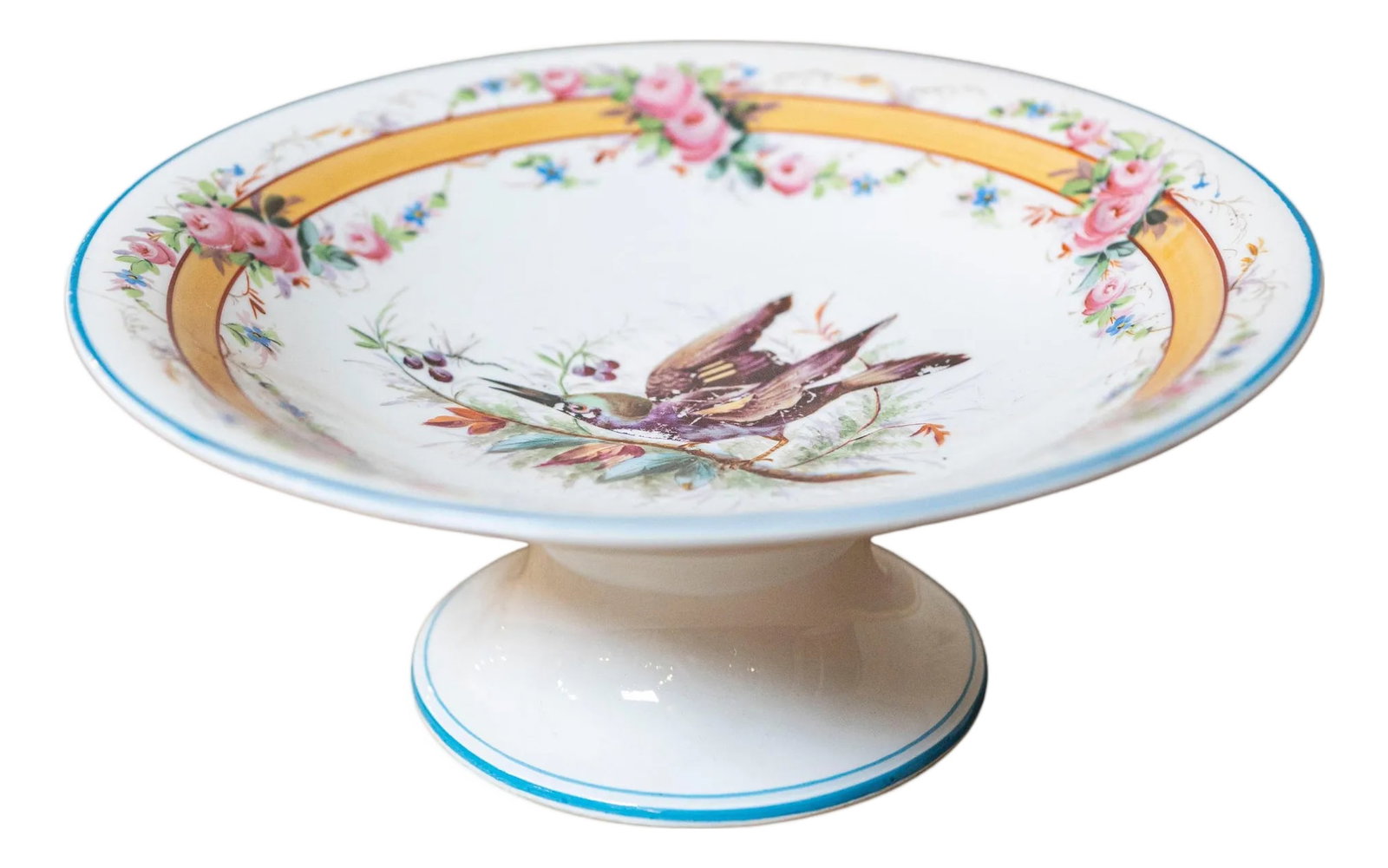 Early 20th French, Hand-Painted Porcelain Compote with Birds and Floral Motif: A beautifully hand-painted porcelain compote dish featuring an elegant pedestal form and richly detailed decoration. The interior showcases a pair of birds perched among delicate foliage, rendered in 