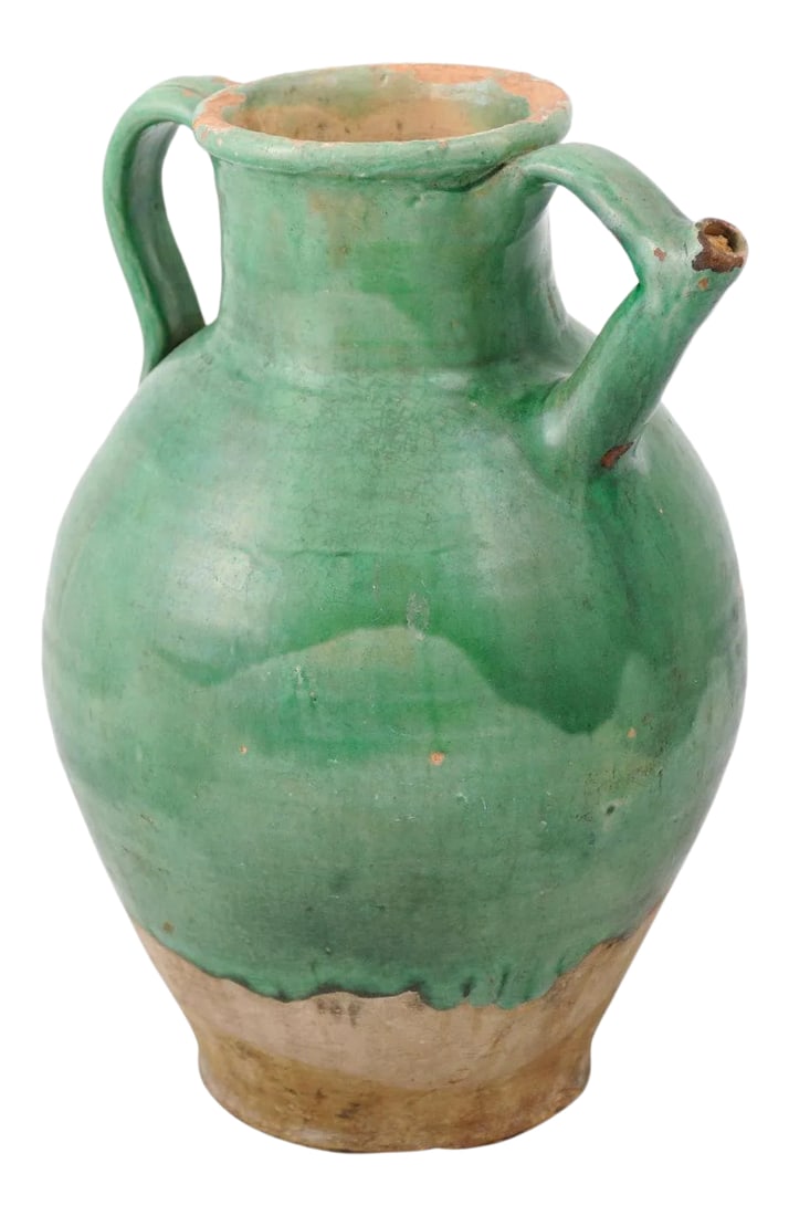 19th Century French Provincial Distressed Green Glazed Pottery Jug: A French provincial green glazed pottery jug from the 19th century, with double handles, front spout and unfinished base. Created in France during the 19th century, this jug features a green glazed