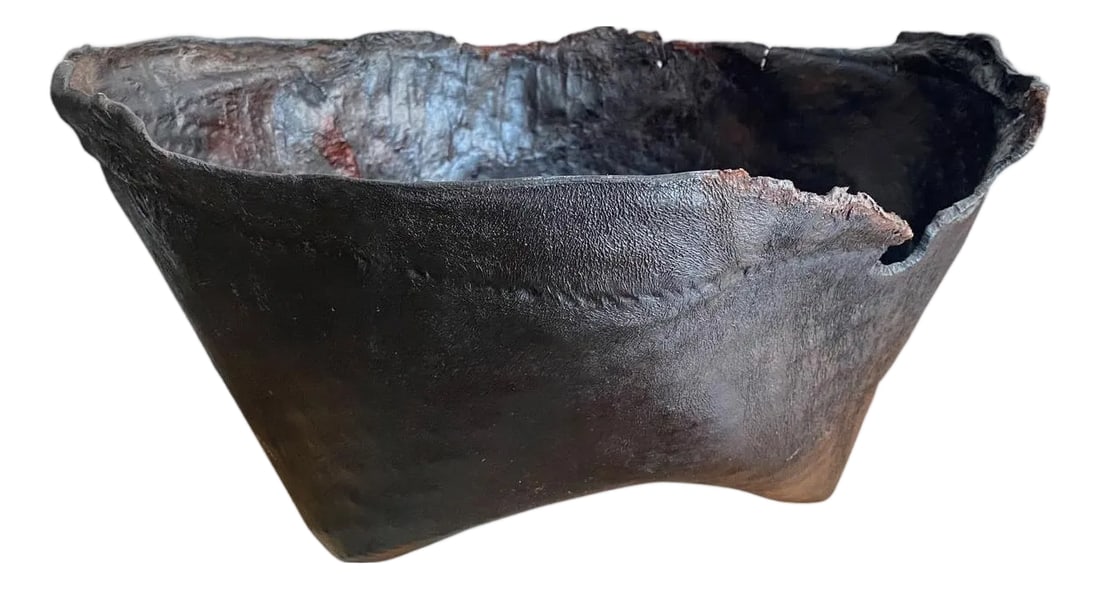 Polished Buffalo Hide Container: Antique container from Borneo made from aged buffalo hide with a natural organic live edge rim. We discovered a beautiful patina after polishing. Great for holding magazines, towels, or simply as a