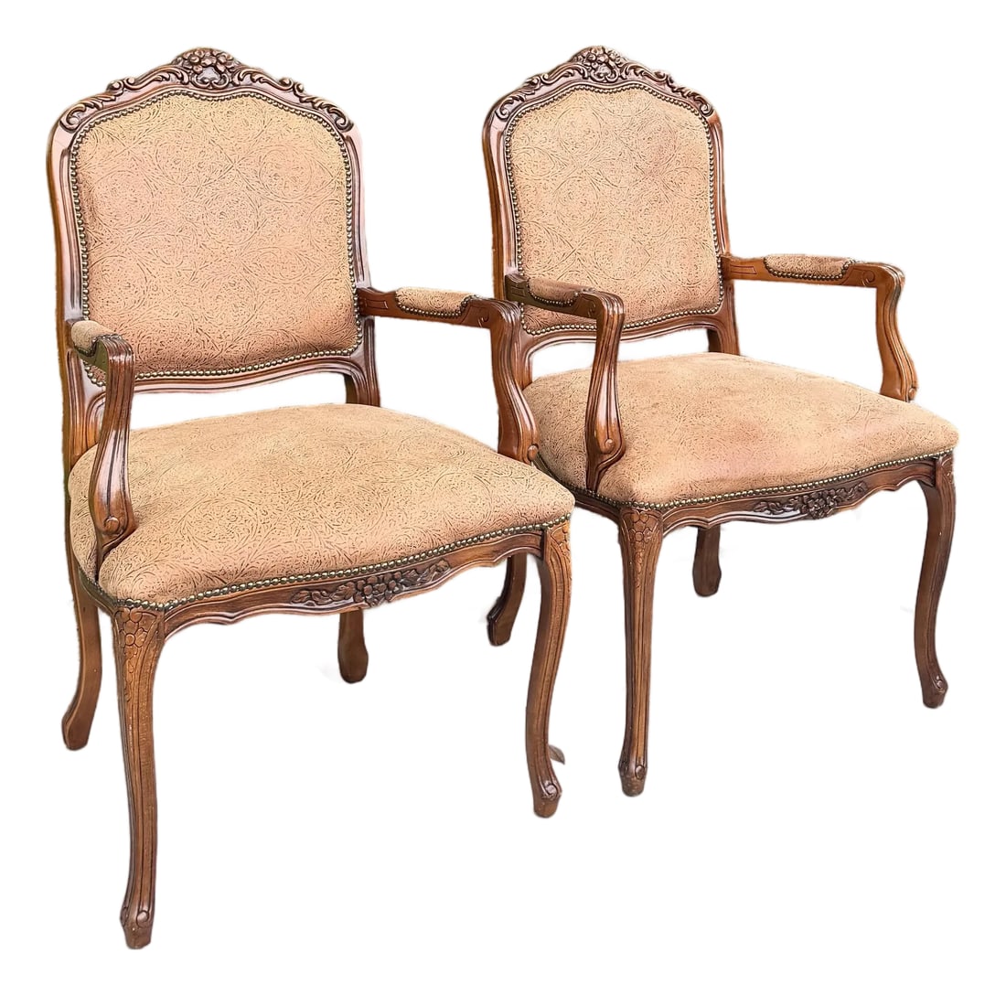 French Provincial Brown With Nailed Vinyl Occasional Chairs - A Pair: A refined pair of French Provincial occasional chairs featuring intricately carved wooden frames with graceful cabriole legs and scrolled arms. Upholstered in embossed brown vinyl secured with