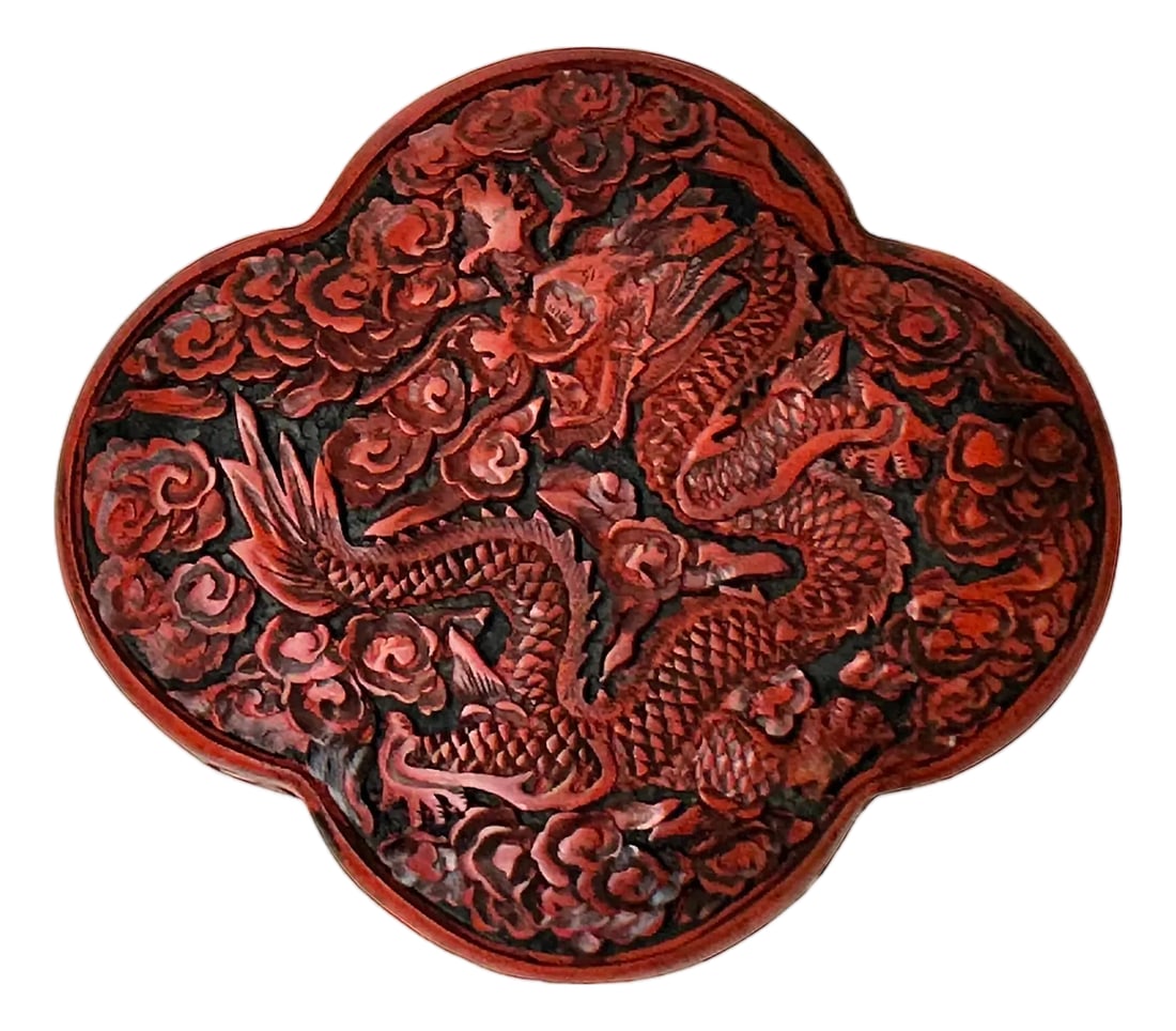 Handcrafted Vintage Chinese Red Lacquer Four Lobed Floral Accent Box: This lobed, cinnabar-style lidded box is a striking example of traditional Chinese decorative art, featuring a rich, deep red exterior that contrasts sharply with its polished black interior. The lid