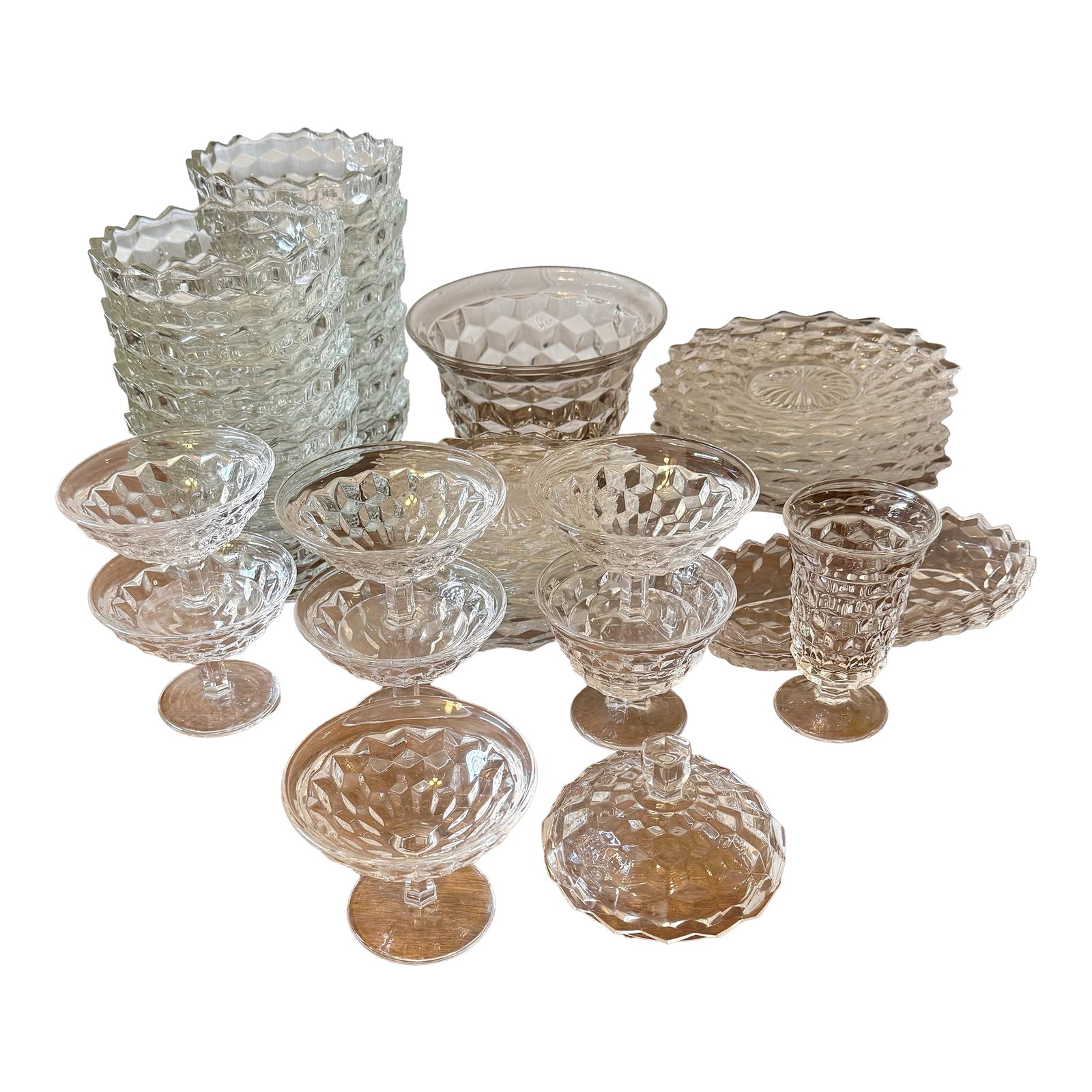 Fostoria American Cubist Dish Collection - 47pcs: This collection of glassware by Fosteria Glass Company is known for their sturdy construction and classic aesthetic. These dishes were designed for everyday use and collectible purposes. The intricate