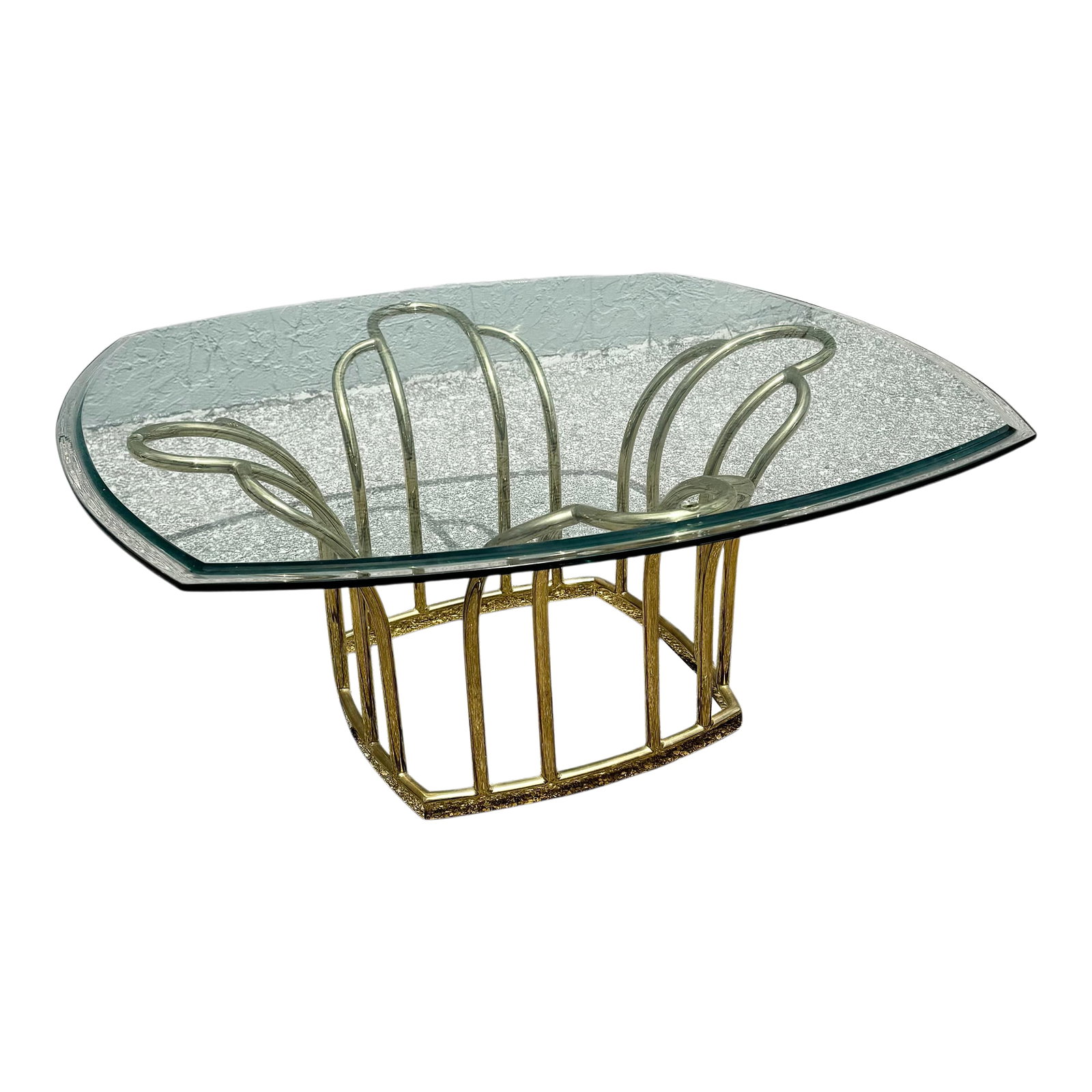 Art Deco Gold Glass Top Coffee Table: Distinctive Art Deco style coffee table featuring a sculptural brass-tone metal base paired with a beveled glass top. The base is formed from gracefully curved tubular elements arranged in a geometric